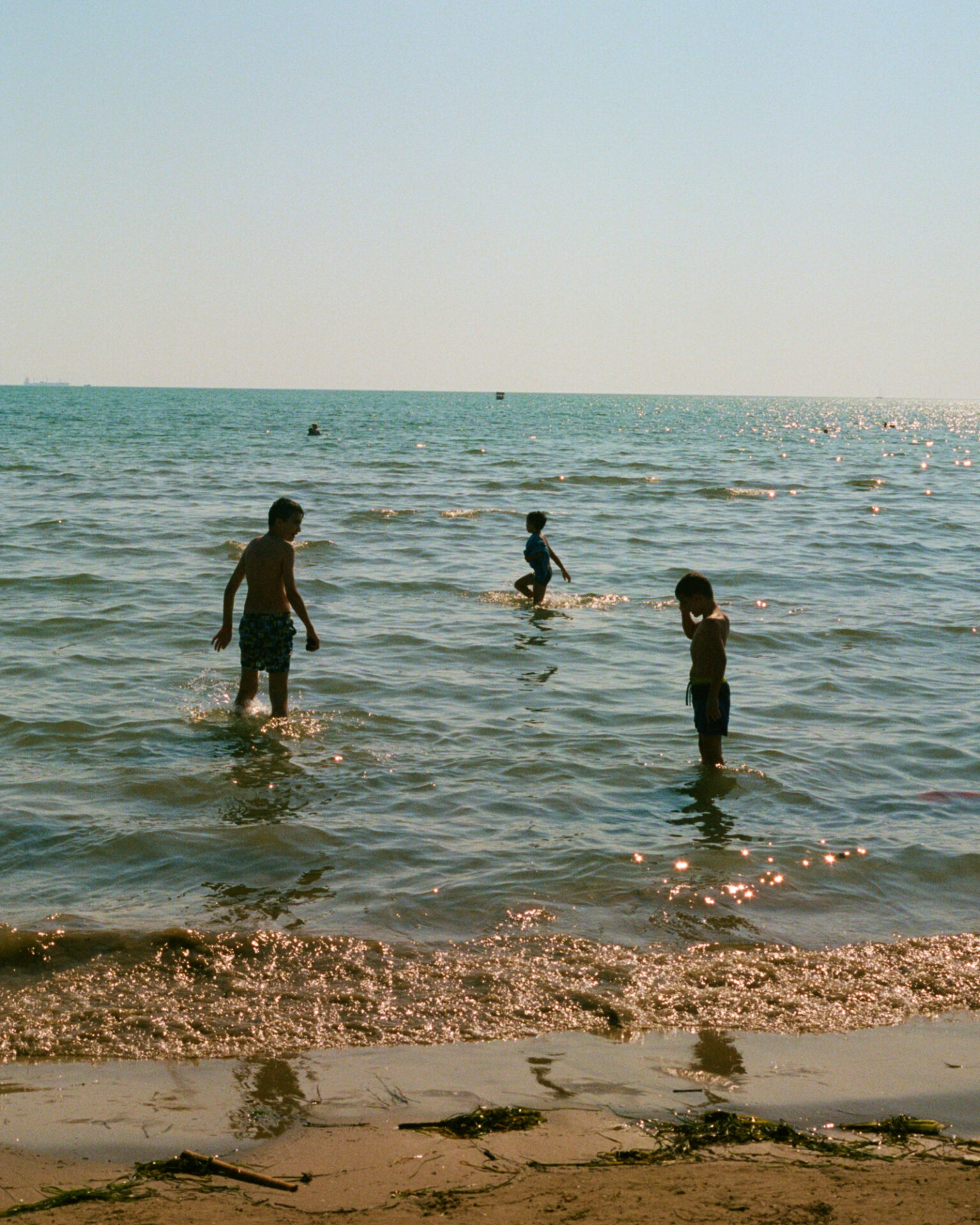 Hazel Gaskin | three boys playing in the sea in the late-afternoon sun in Durres