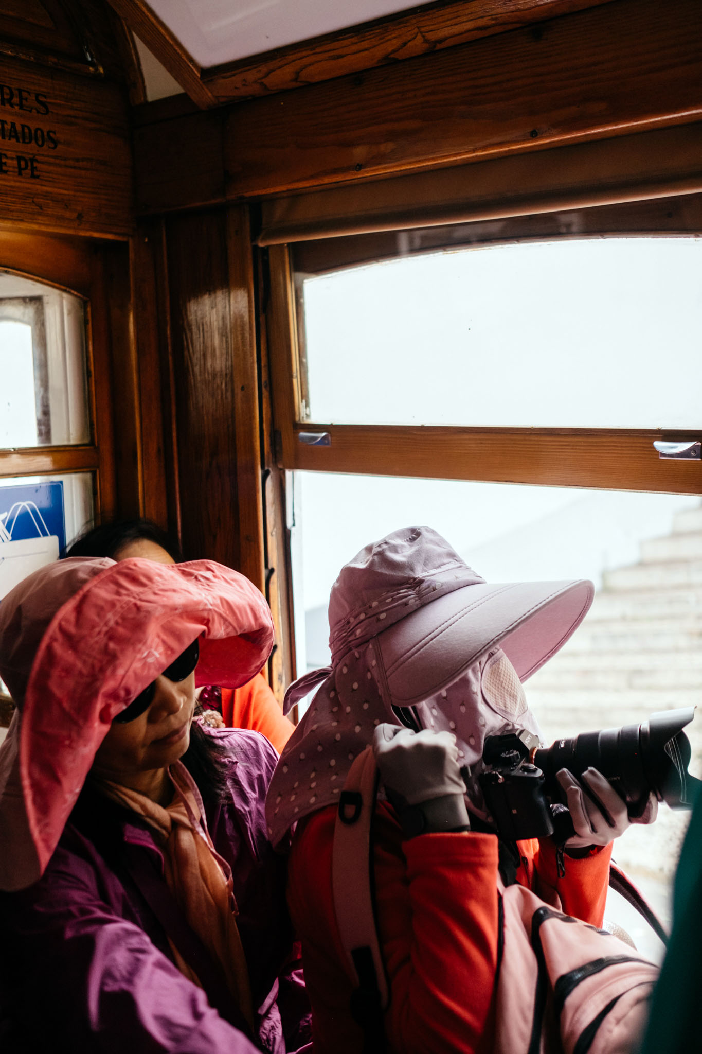 Two people on a bus looking out the window in Lisbon by photographer Emma Croman