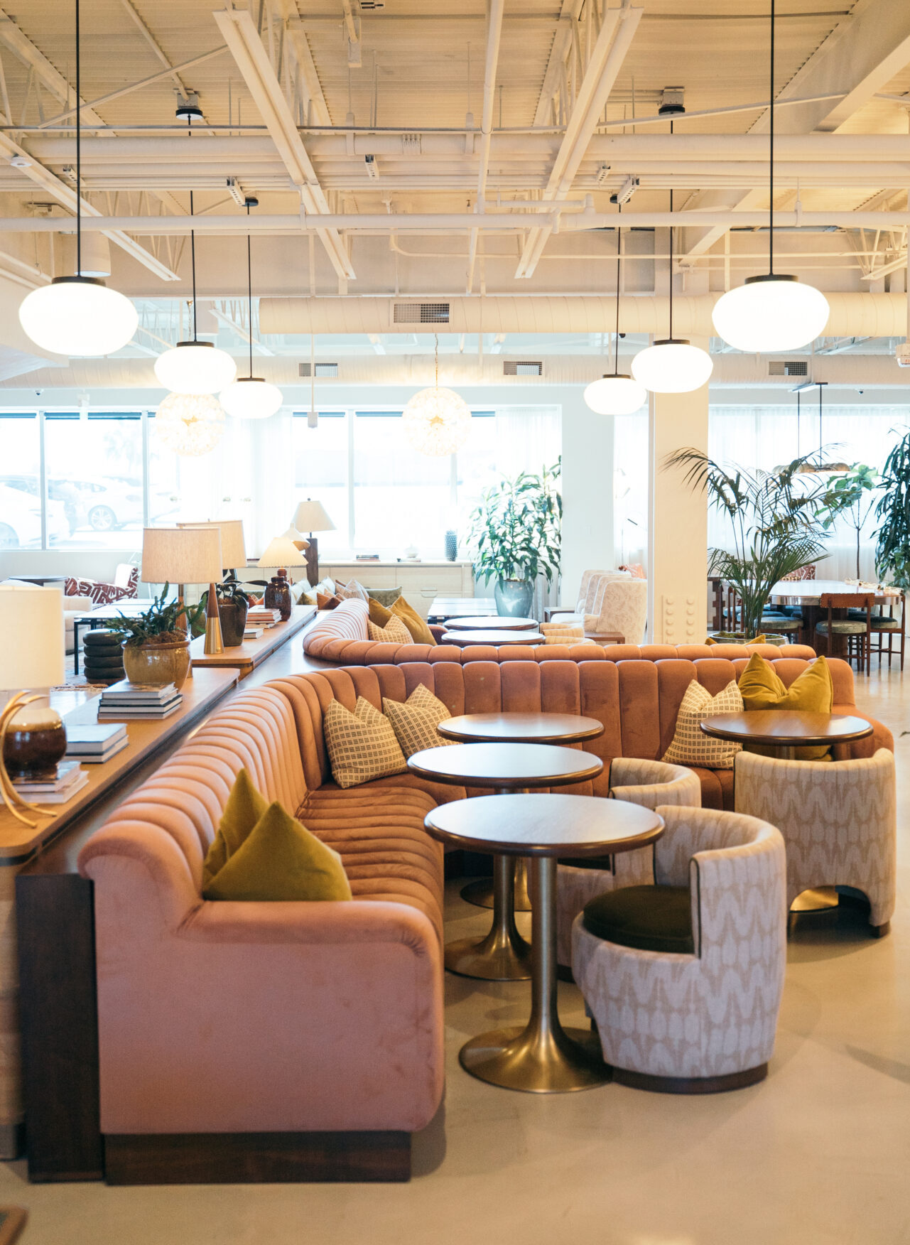 Best places to co-work in LA | An interior view of Soho Works, where a pink corner banquet sofa surrounds three round tables