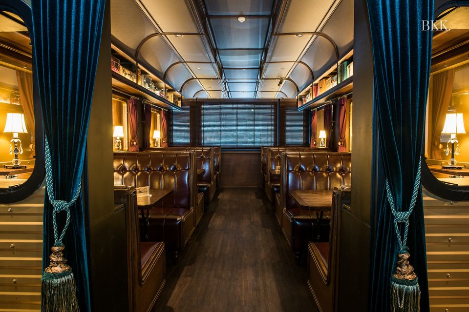 Best Bangkok restaurants | The train carriage-inspired dining room at Burapa, with dark-blue velvet curtains and gold décor