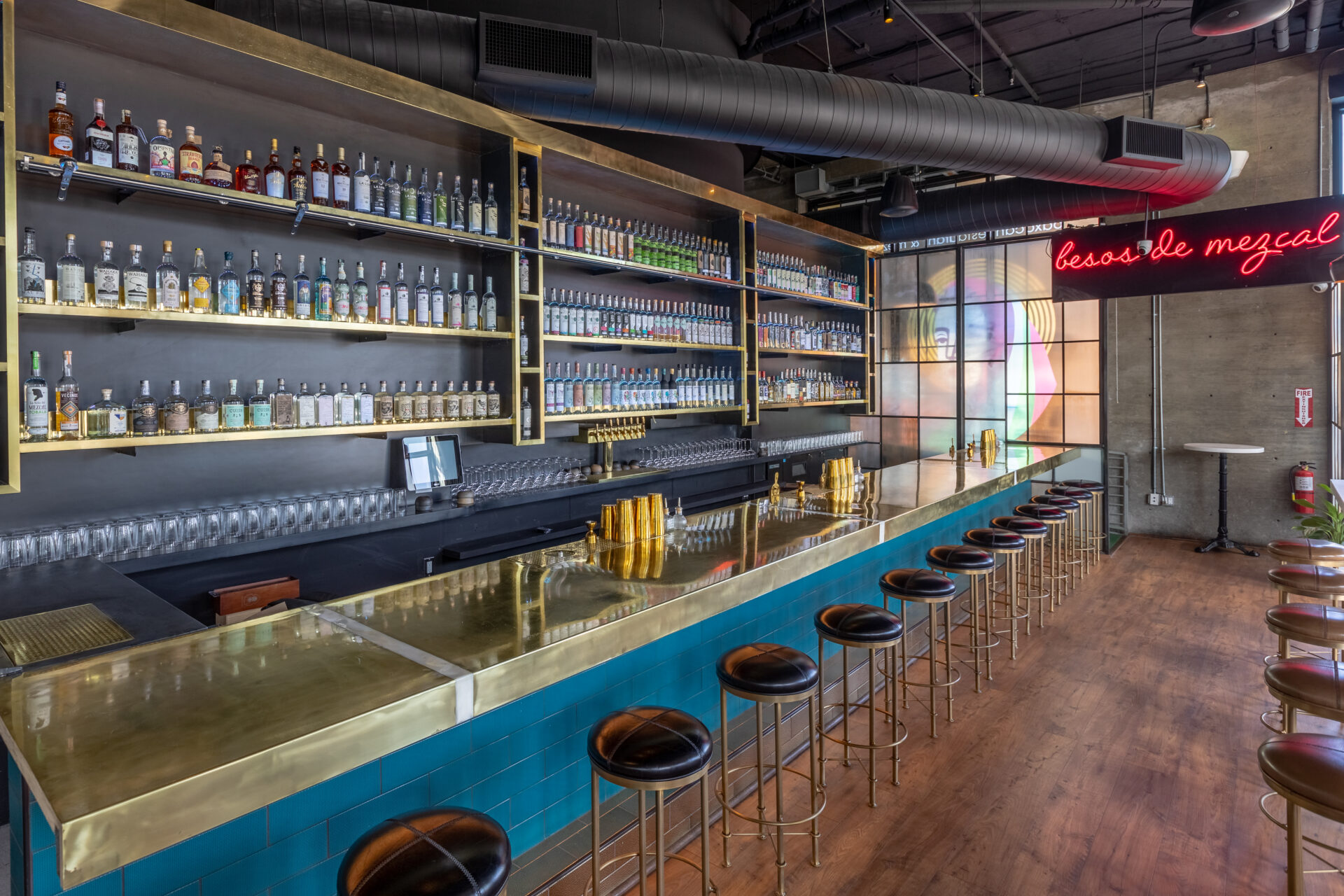 Best restaurants LA | The bar area at Madre, with a gold-topped bar, blue tiling and wooden floors