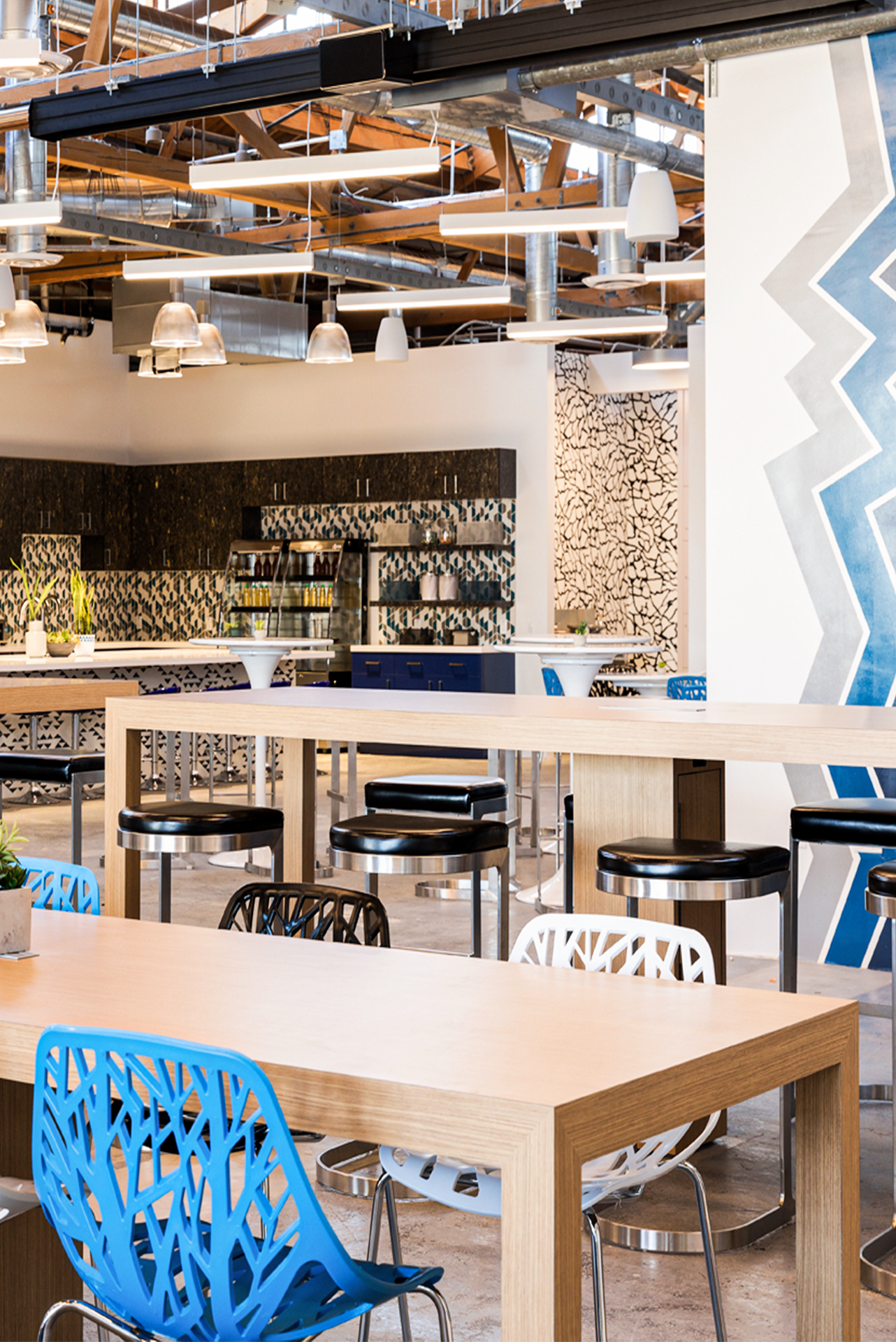 LA co-working spaces | A communal area at Phase Two Culver City, with light-wood long tables, blue chairs and blue design accents