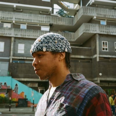 Taylor Simmons | a side profile shot of the artist standing outside in Aldgate, London. Photo by Sophie Davidson