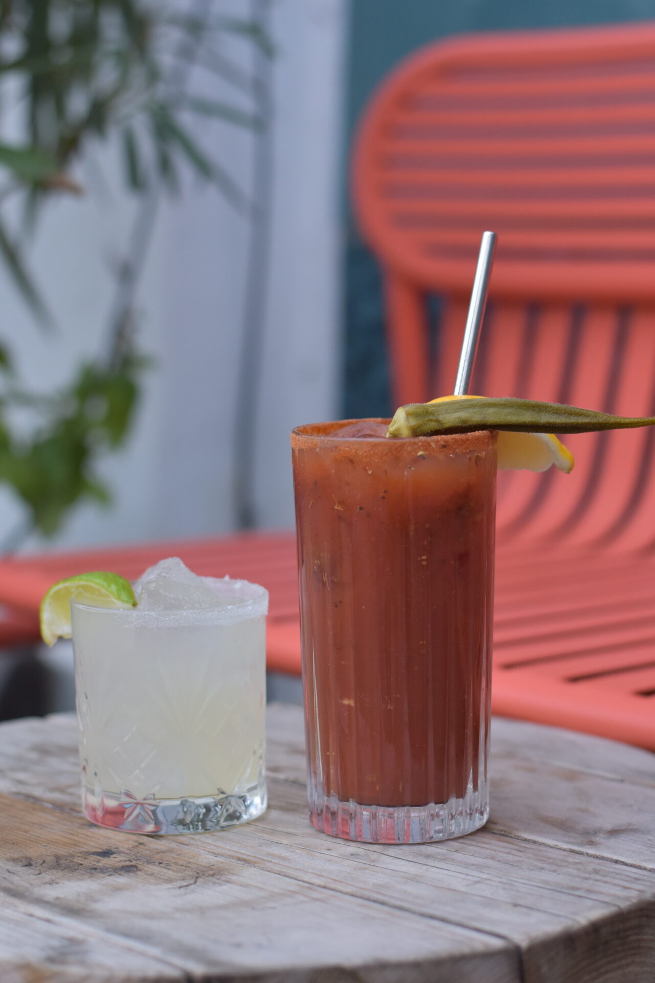 Things to do in London this month | Two cocktails on a wooden table in front of a red metal chair at Plaquemine Lock