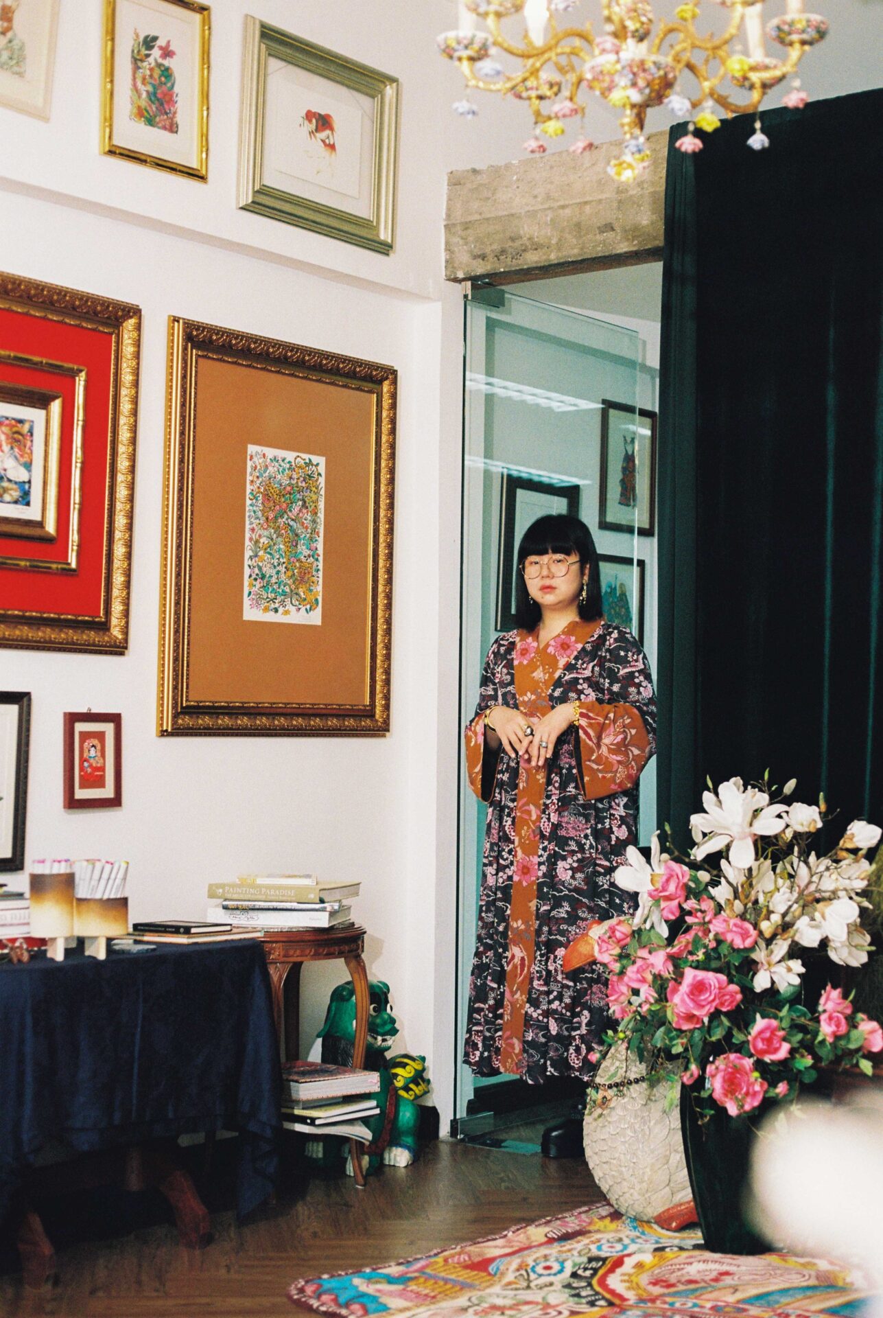 Phannapast | The Bangkok artist wearing a floral kimono in her studio, with white walls and colourful artwork in frames