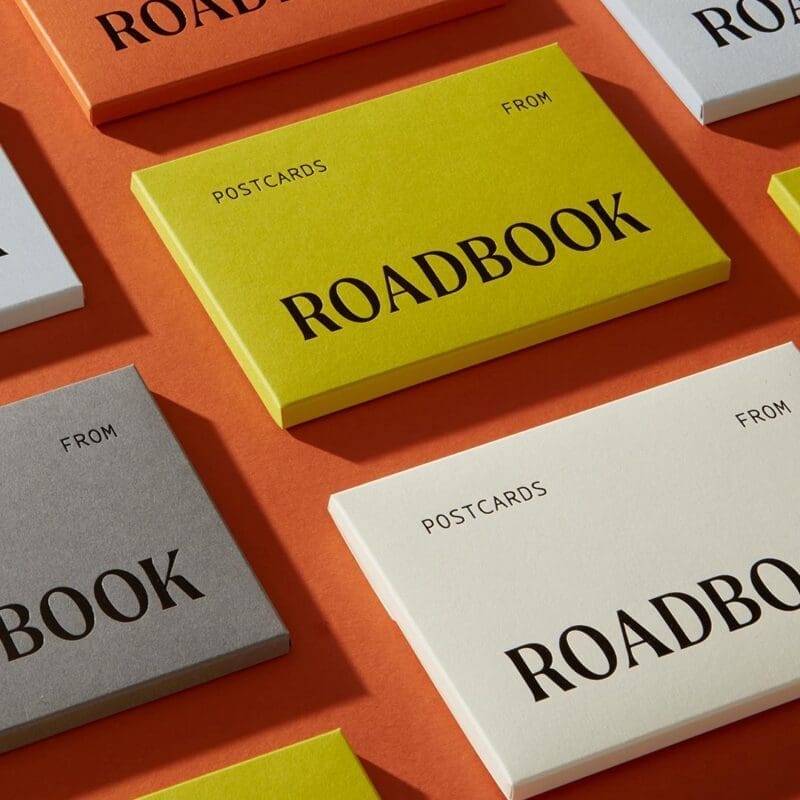 Postcards from ROADBOOK | Brightly coloured boxes in orange, green, white and grey emblazoned with the words ROADBOOK sit against an orange background