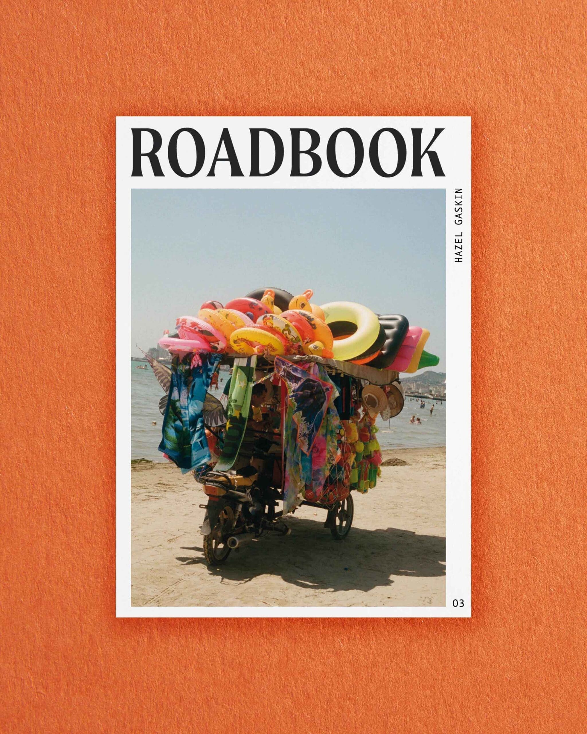 Postcards from ROADBOOK | Brightly coloured beach paraphernalia including inflatable rubber rings on a bike on a beach by Hazel Gaskin