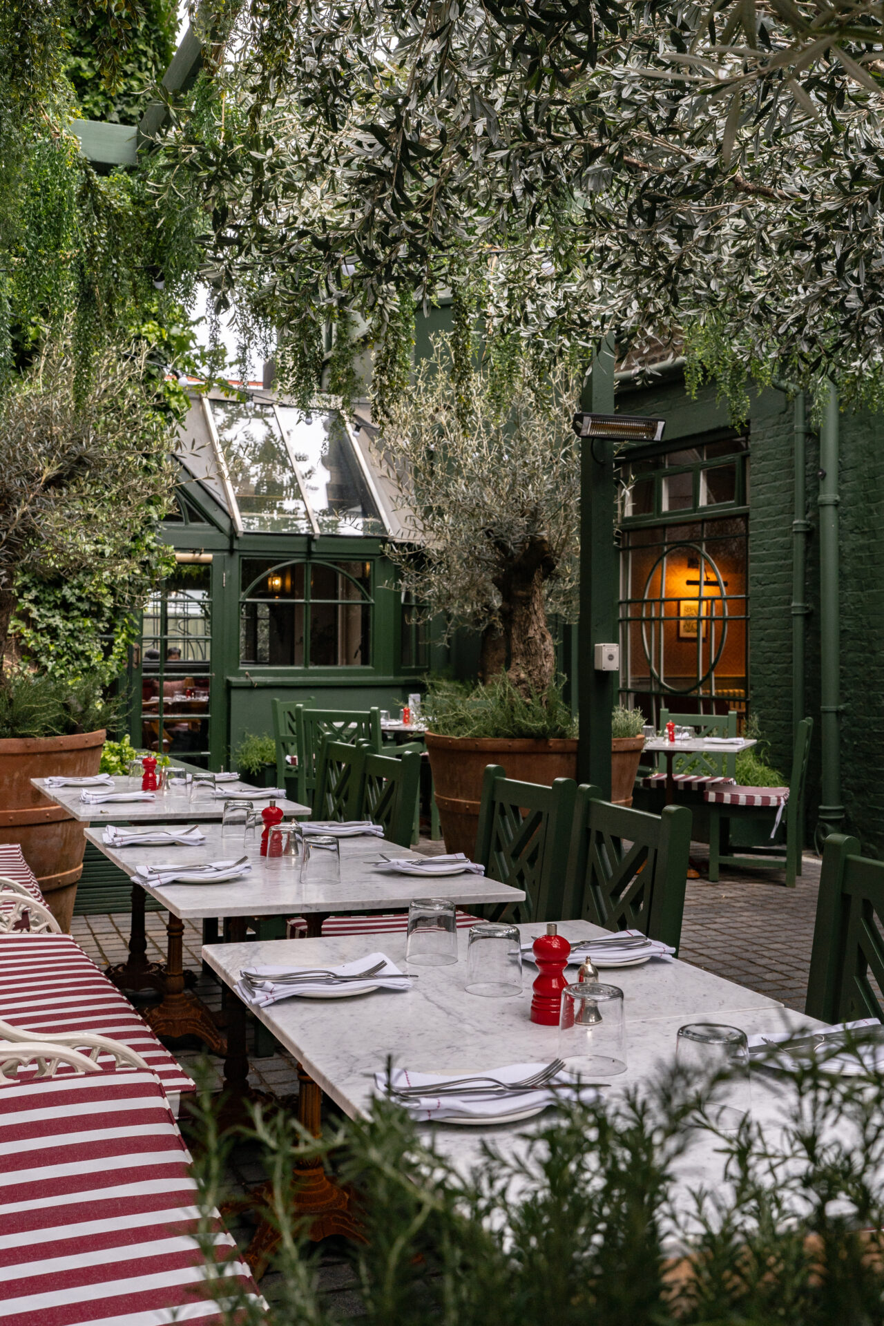 Best restaurants with outdoor seating in London | Princess Royal's terracr with marble-topped tables, red-and-white striped cushions, shaded by greenery