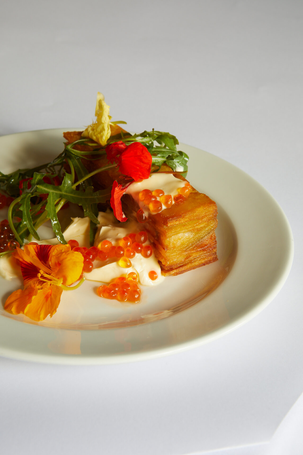Best restaurants with outdoor seating areas in London | The smoked eel and potato cake, with bright orange caviar, a cream-coloured sauce and some green garnishes