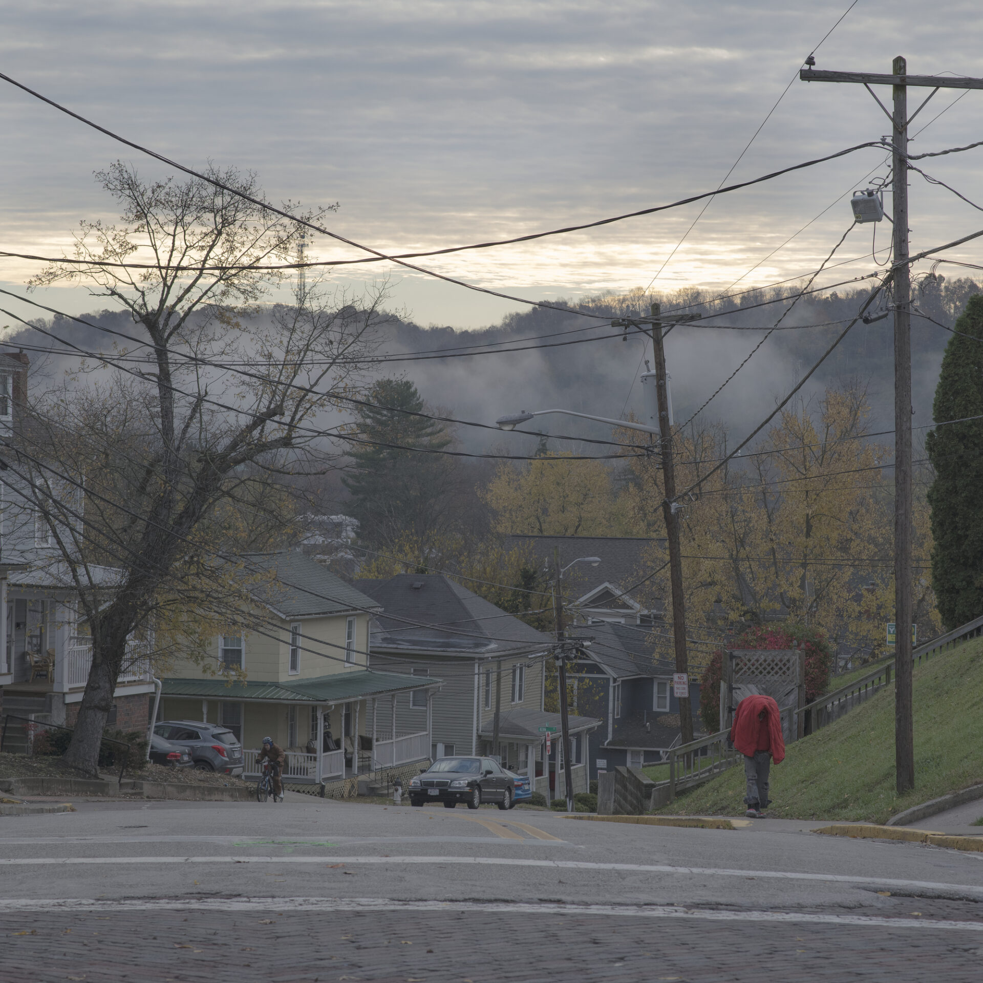 Photographer Rich-Joseph Facun | A scene from Appalachian, looking over some grey-toned wooden houses into a mist-covered valley