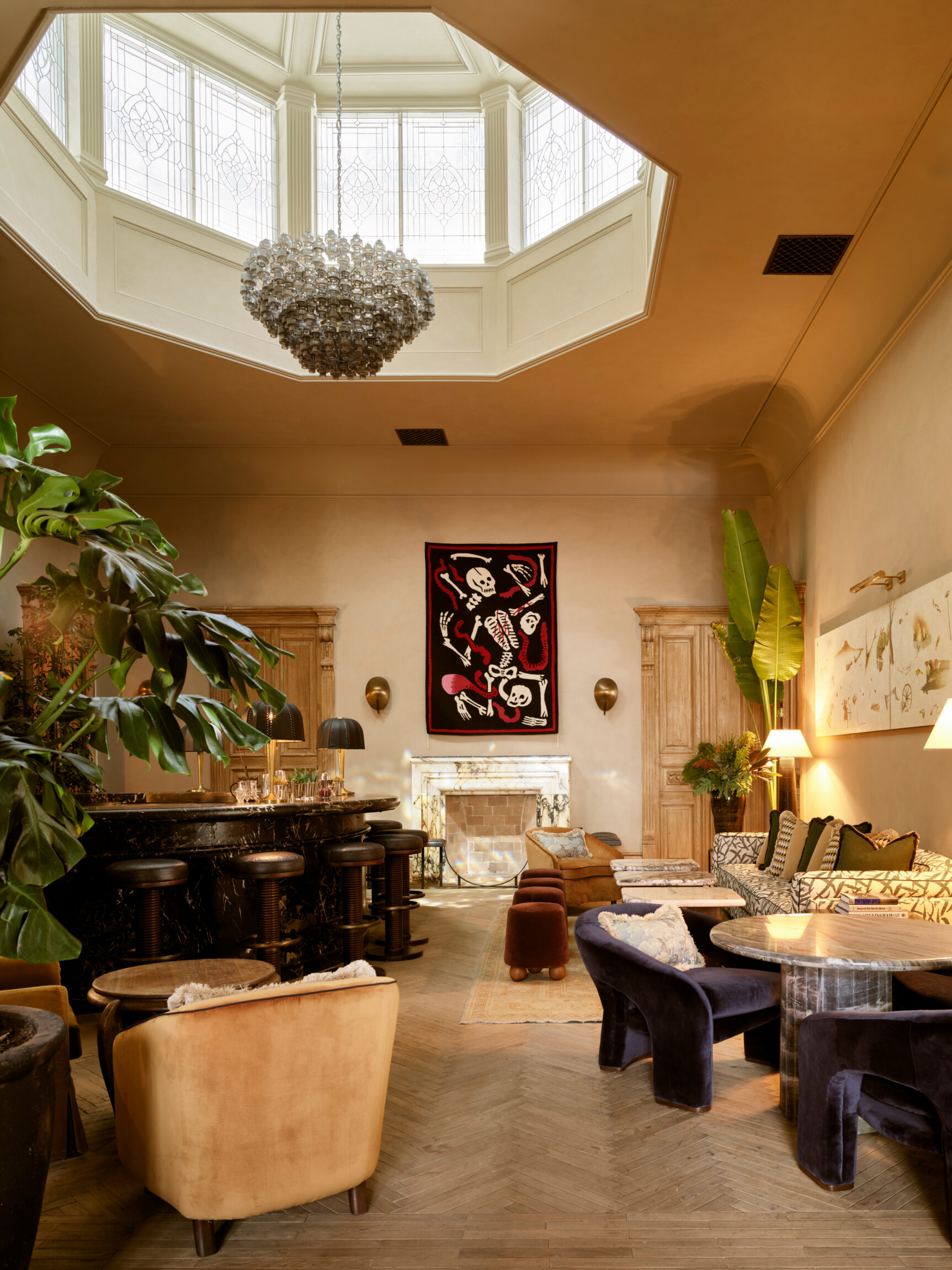 a lounge area with velvet seating and striking skeleton artwork