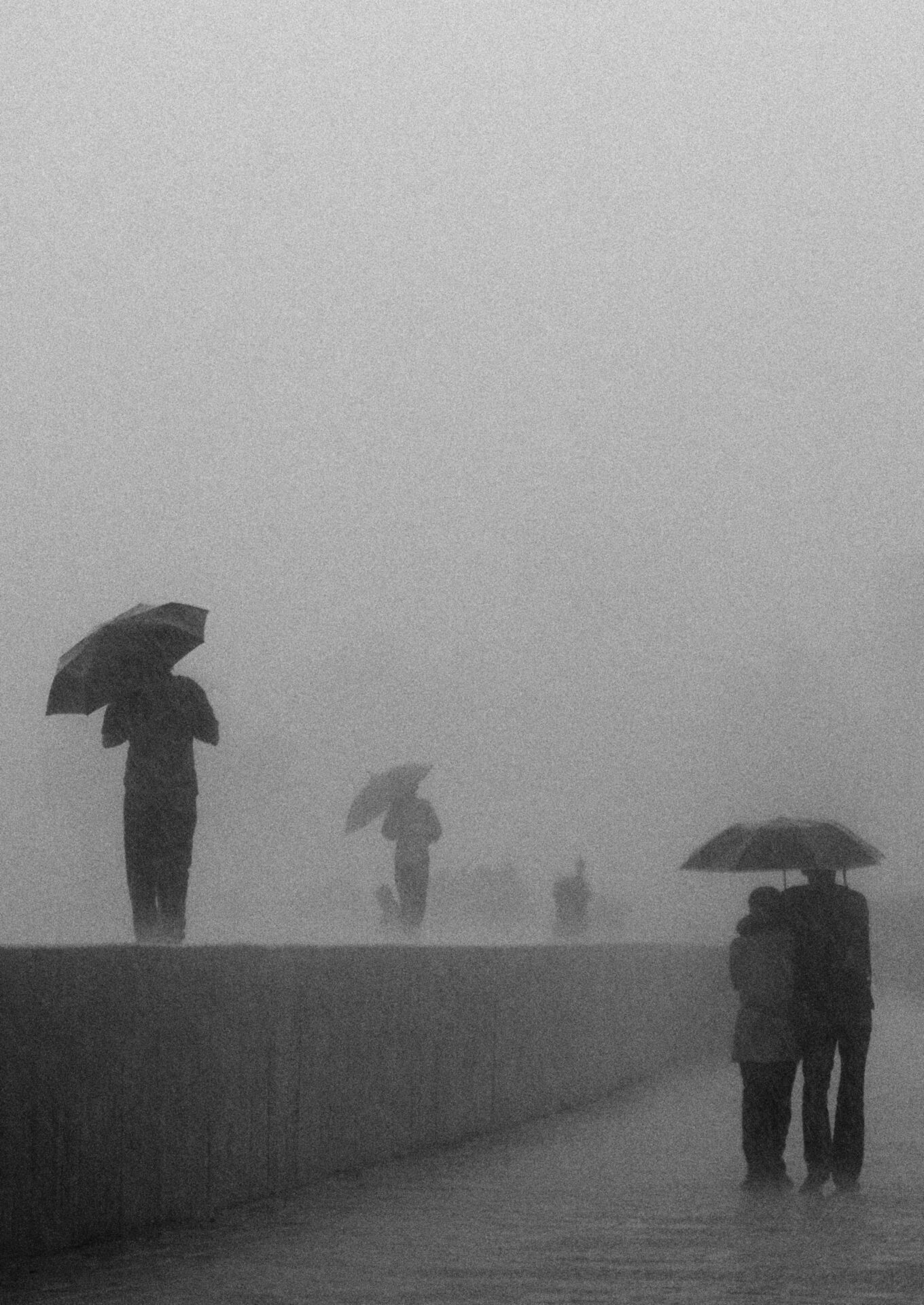 Photographer Sunhil Sippy on Mumbai | Figures holding umbrellas walk through the mist