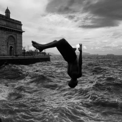 Photographer Sunhil Sippy on Mumbai | the silhouette of a person backflipping into choppy waters