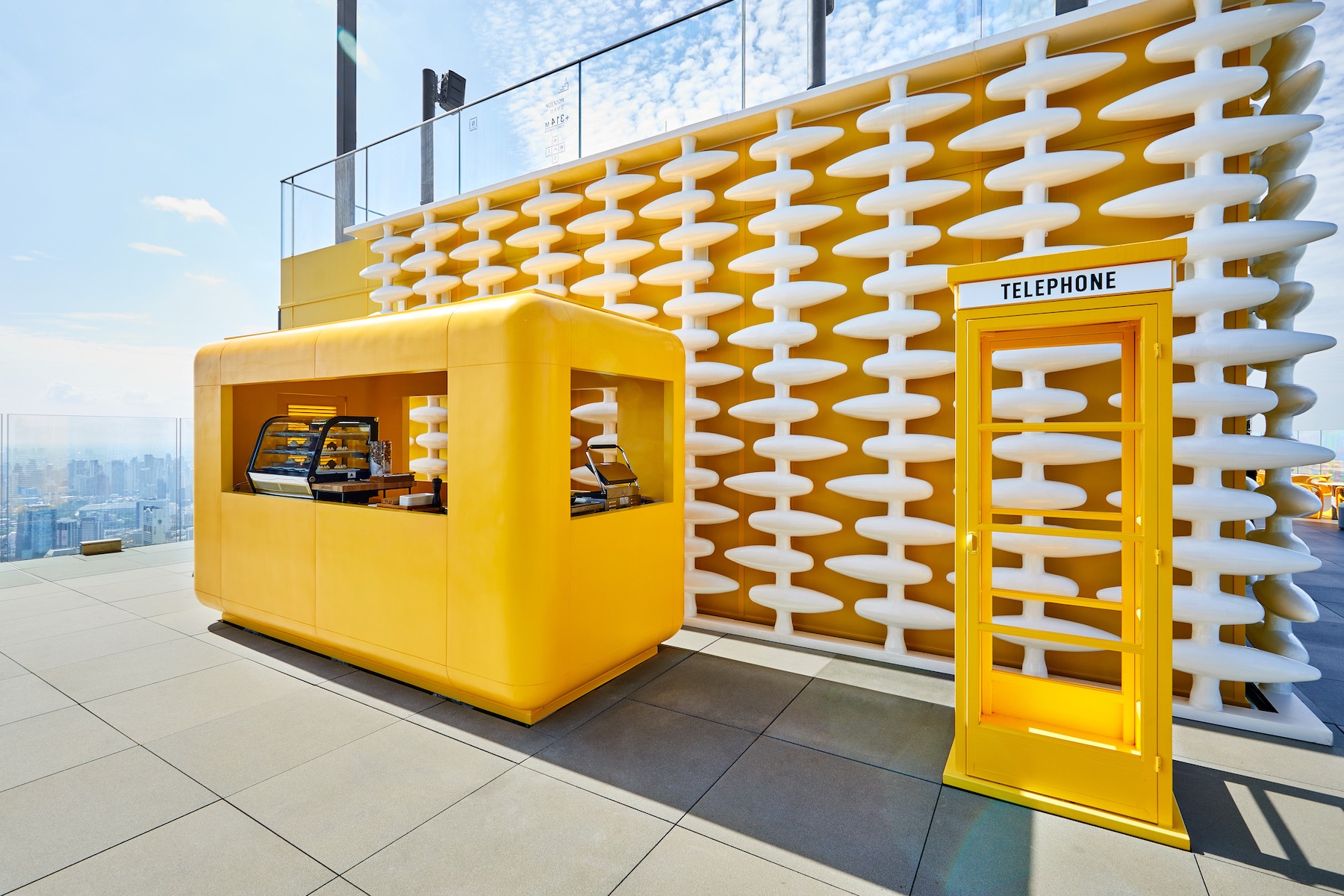 The rooftop Sky Beach bar at The Standard Bangkok | a yellow futuristic bar against a blue sky