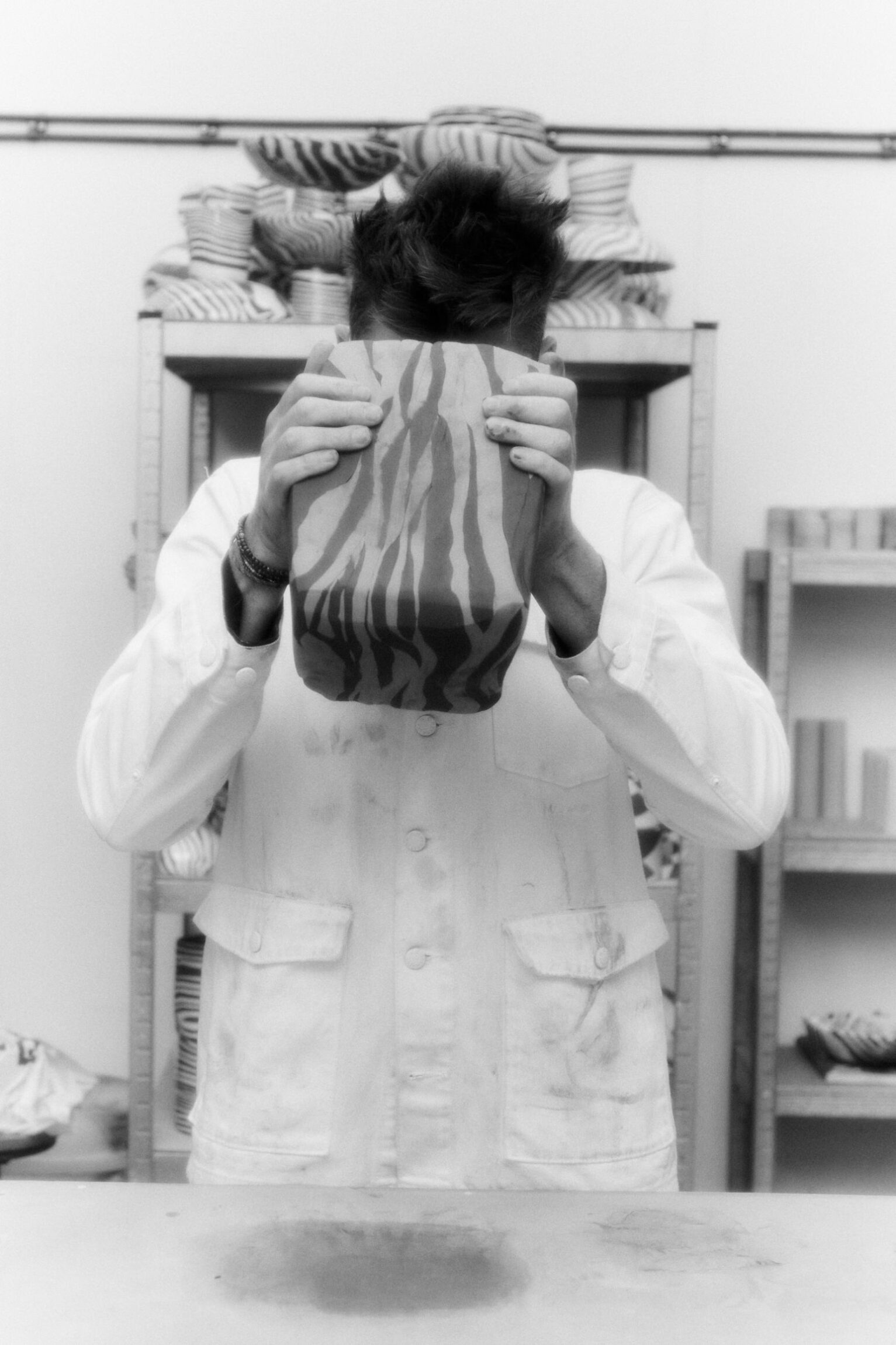 In the studio with Henry Holland | Henry Holland slamming a slab of contrasting clays into a workbench at his studio.