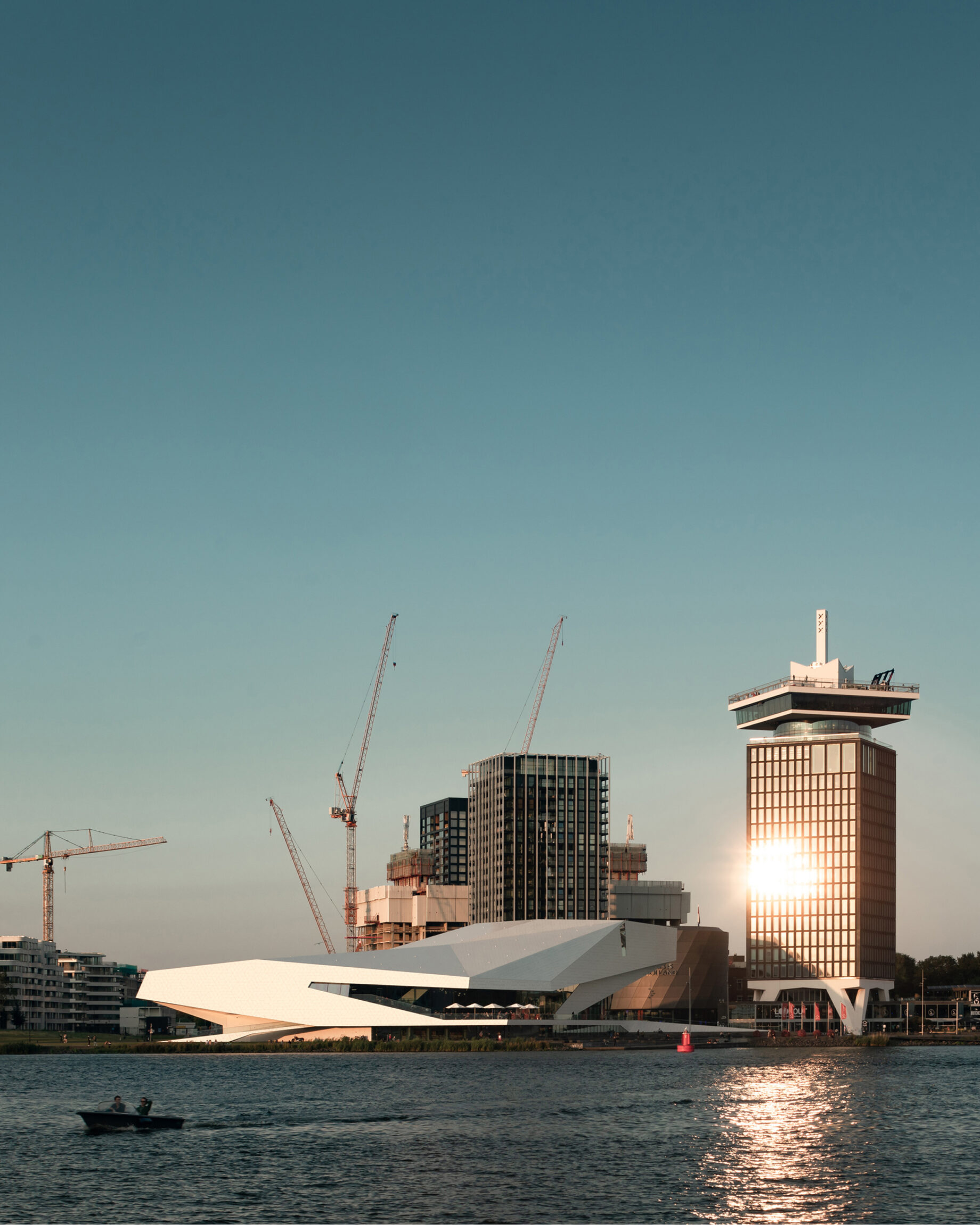 Boat drives along water with the city in the background