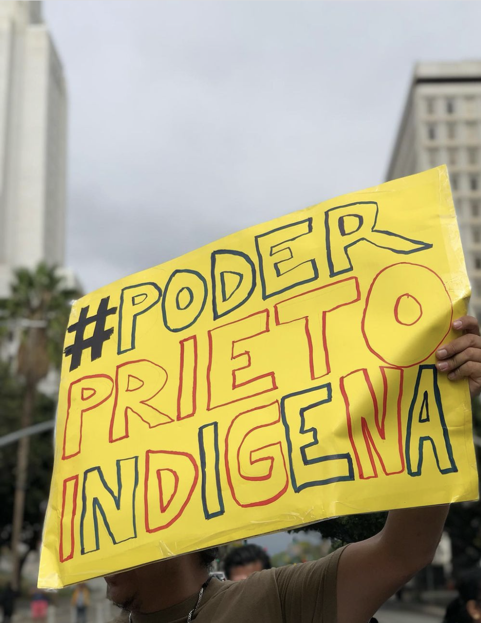 An interview with Ian Vasquez | a yellow sign held up at a protest in Los Angeles