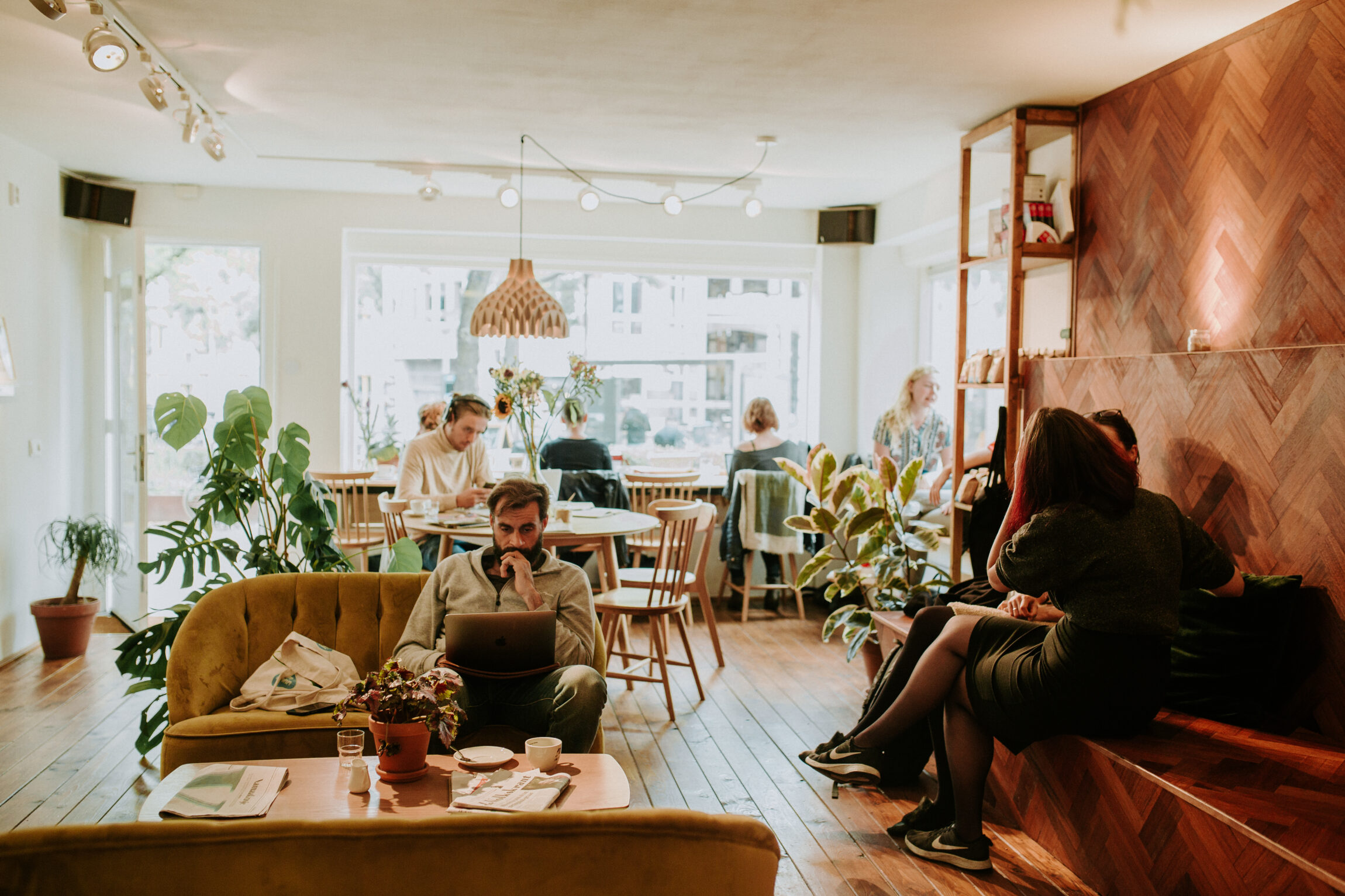 Where to get the best coffee in Amsterdam | People sitting in a coffee shop talking and on their laptops