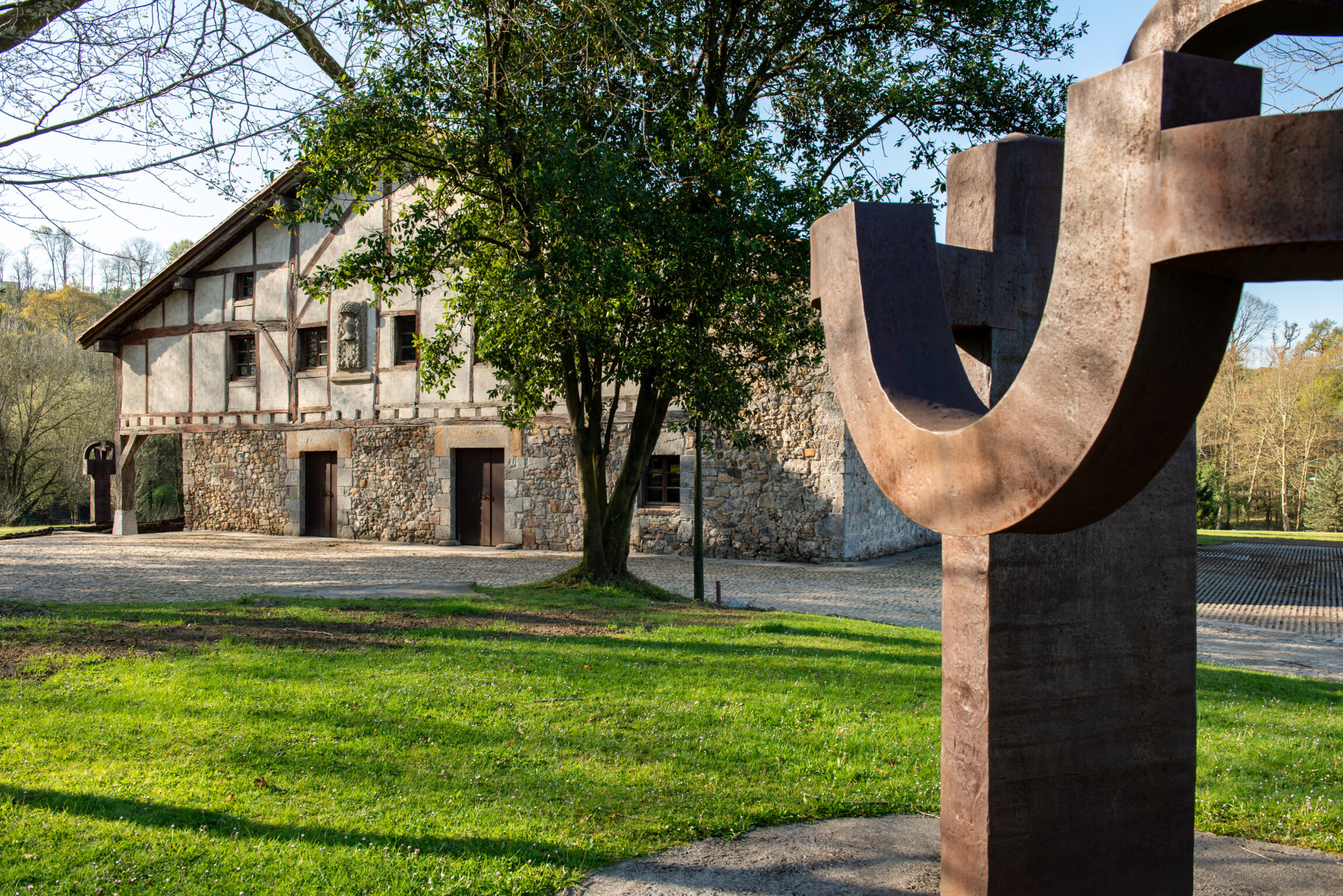 A corten steel sculpture by Eduardo Chillida next to the farmhouse at Chillida Leku near San Sebastian, Spain. Photo by Inigo Santiago