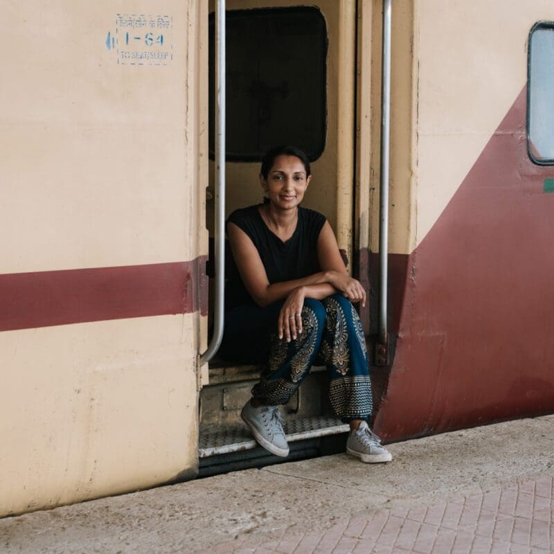 Monisha Rajesh sitting by a train door by Marc Sethi