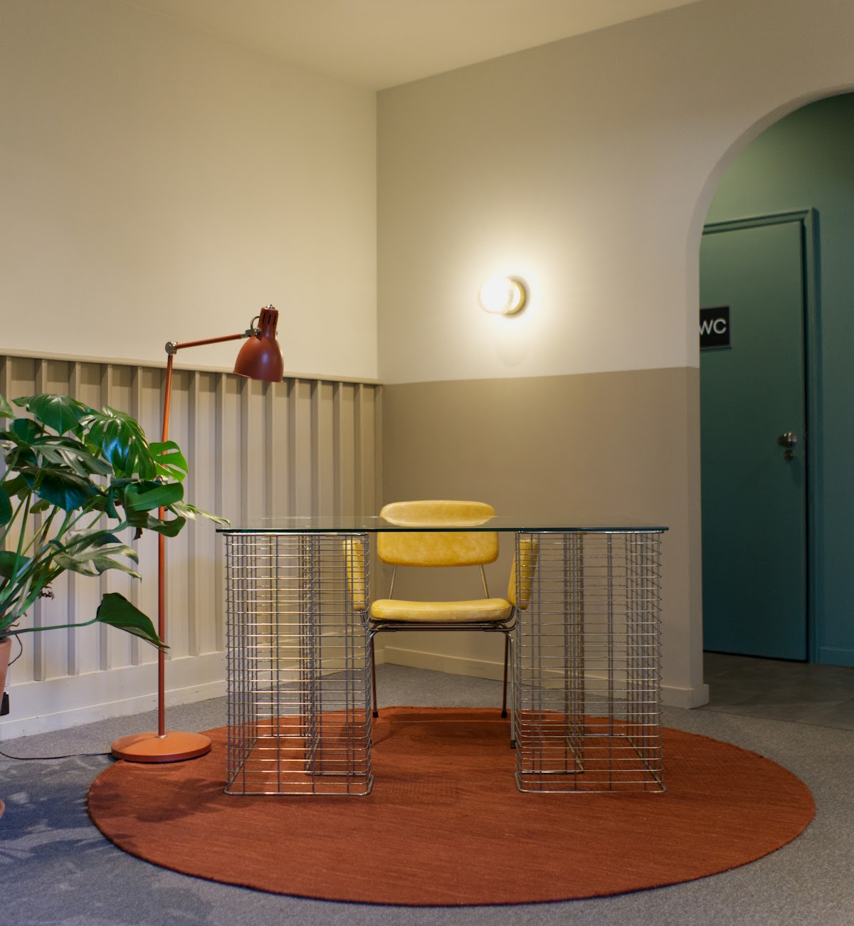 A yellow chair behind a steel wire desk in Impact Hub.