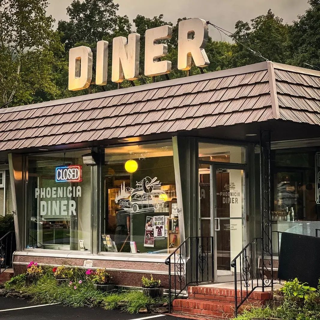 Phoenicia Diner exterior with a retro design surrounded by colourful flowers and trees.