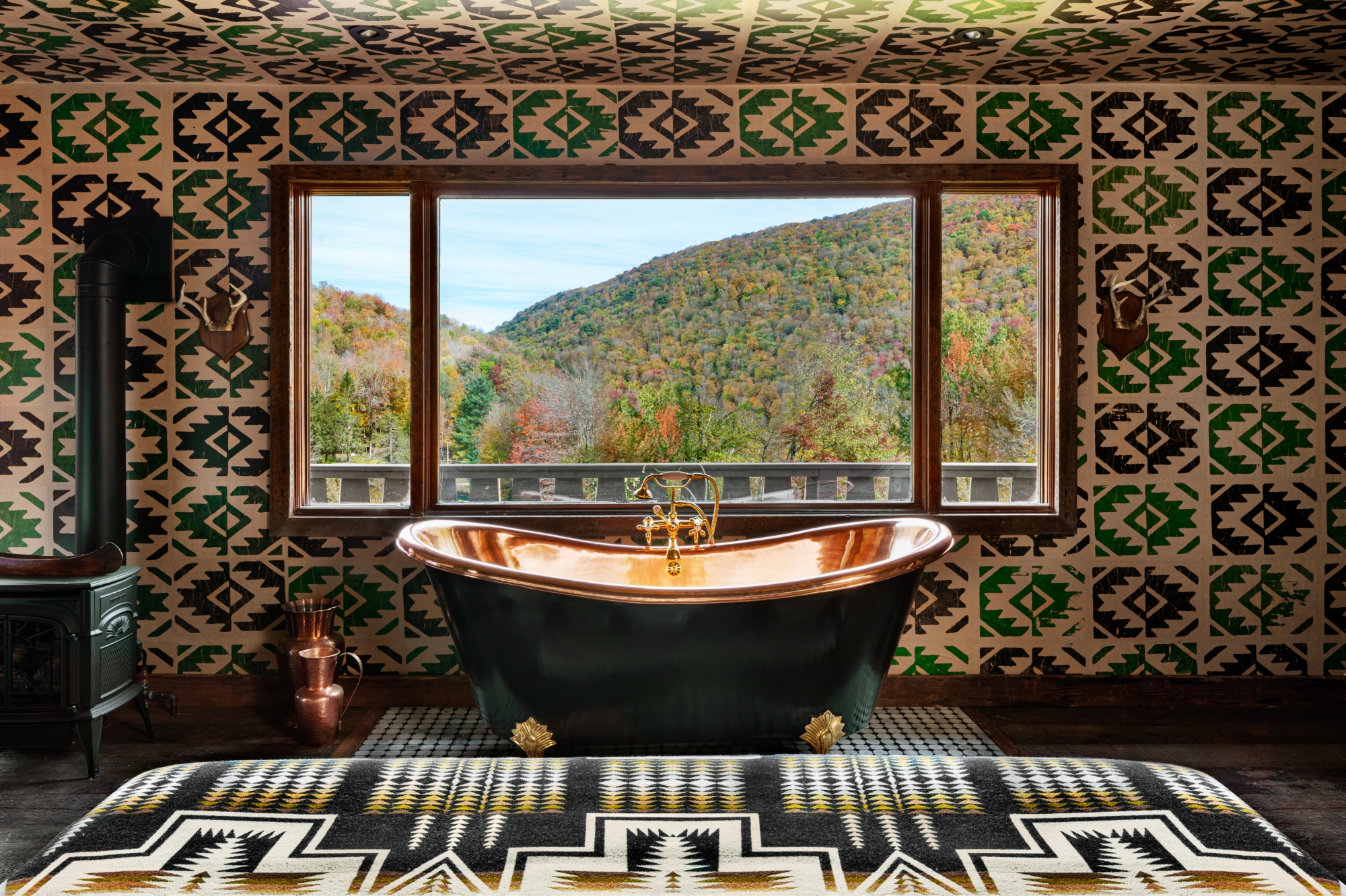 A deep sinking bath tub against a window with mountain views at Urban Cowboy Lodge, Catskills