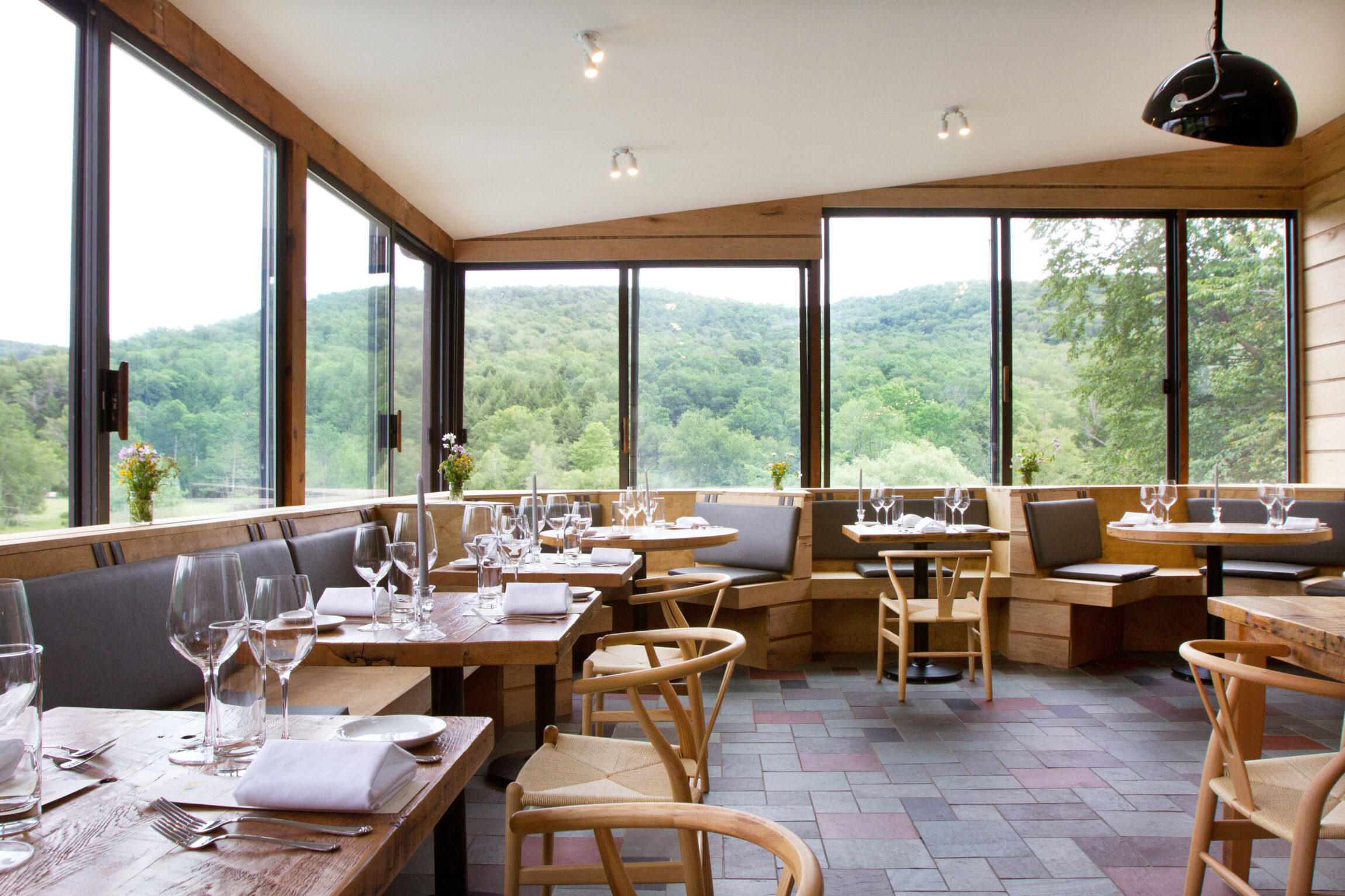 A modern restaurant interior that offer a stunning view of the surrounding greenery