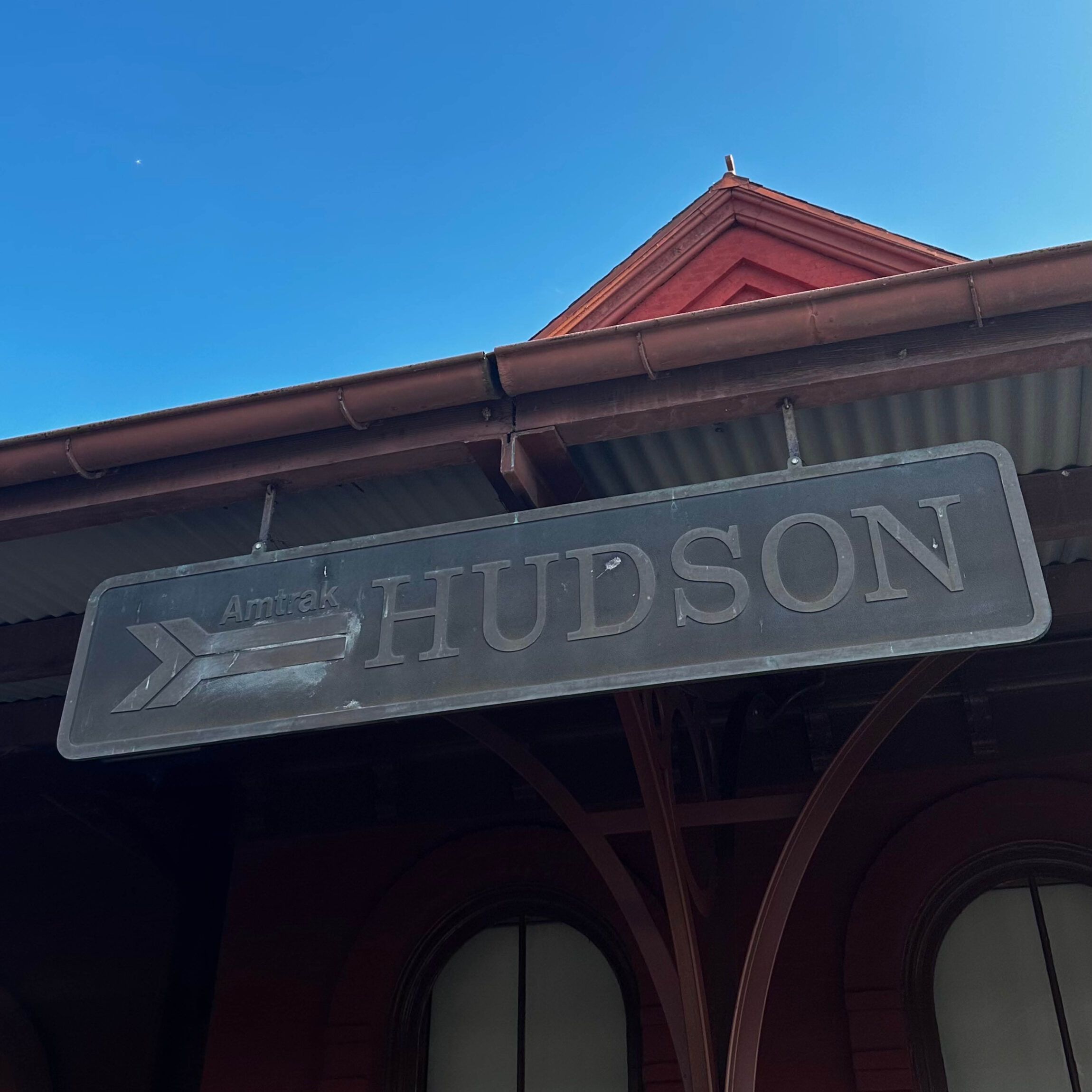 The exterior of Hudson train station beneath a blue sky