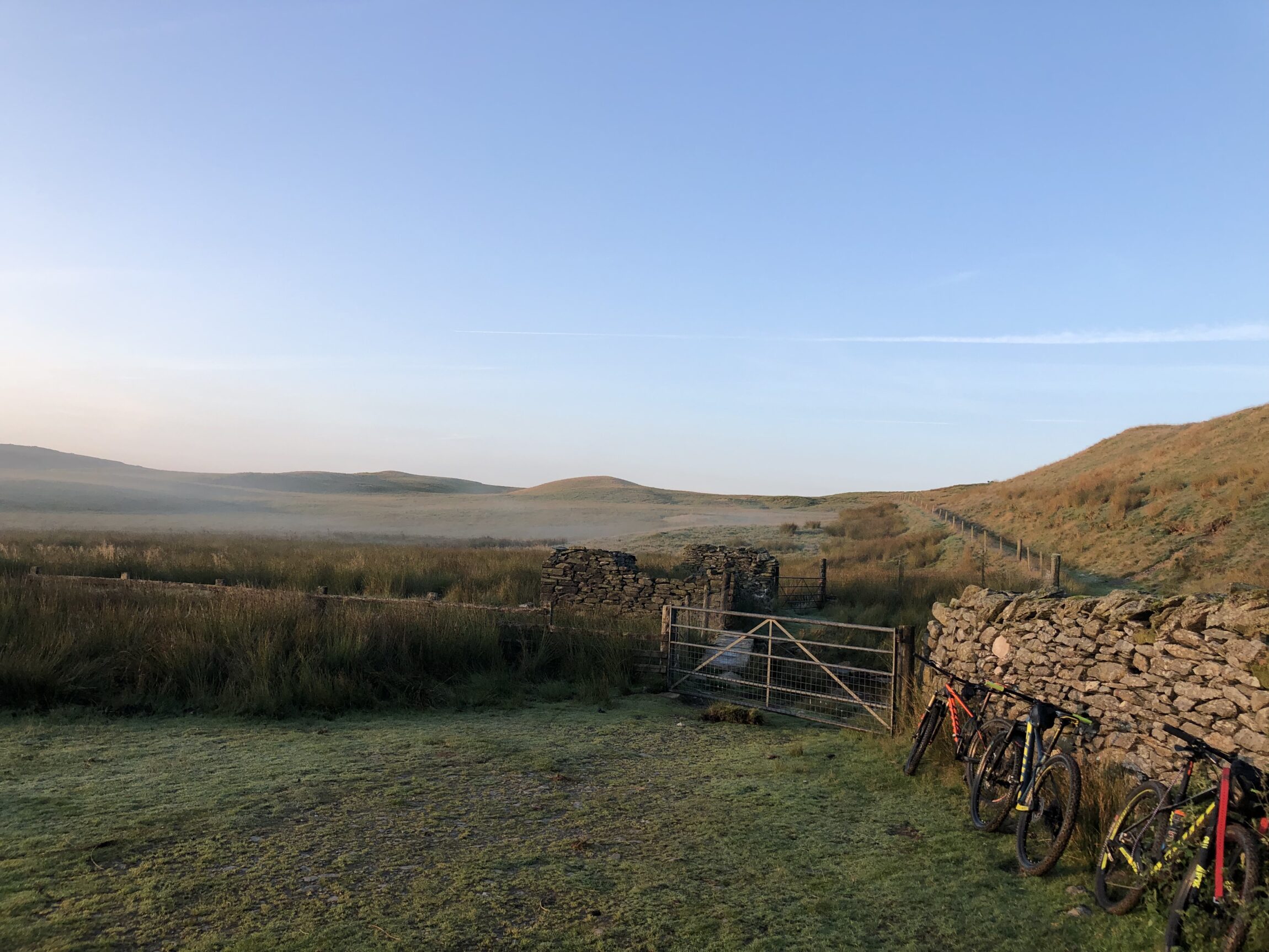 Bikes parked against a stone wall outside a bothy in Wales.