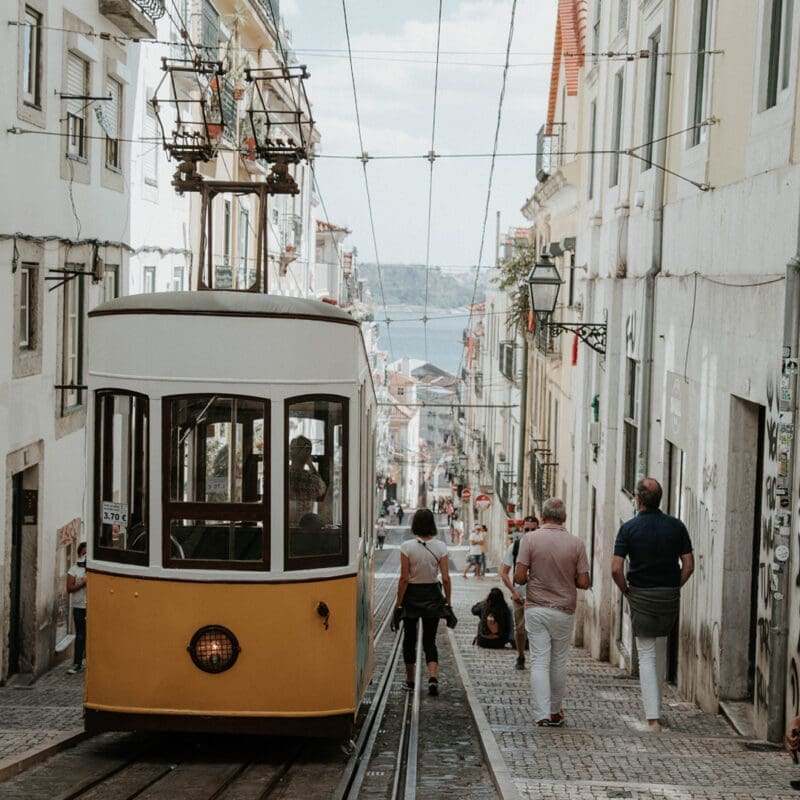 Shoreditch and Spitalfields | A yellow tram drives down a road in Lisbon