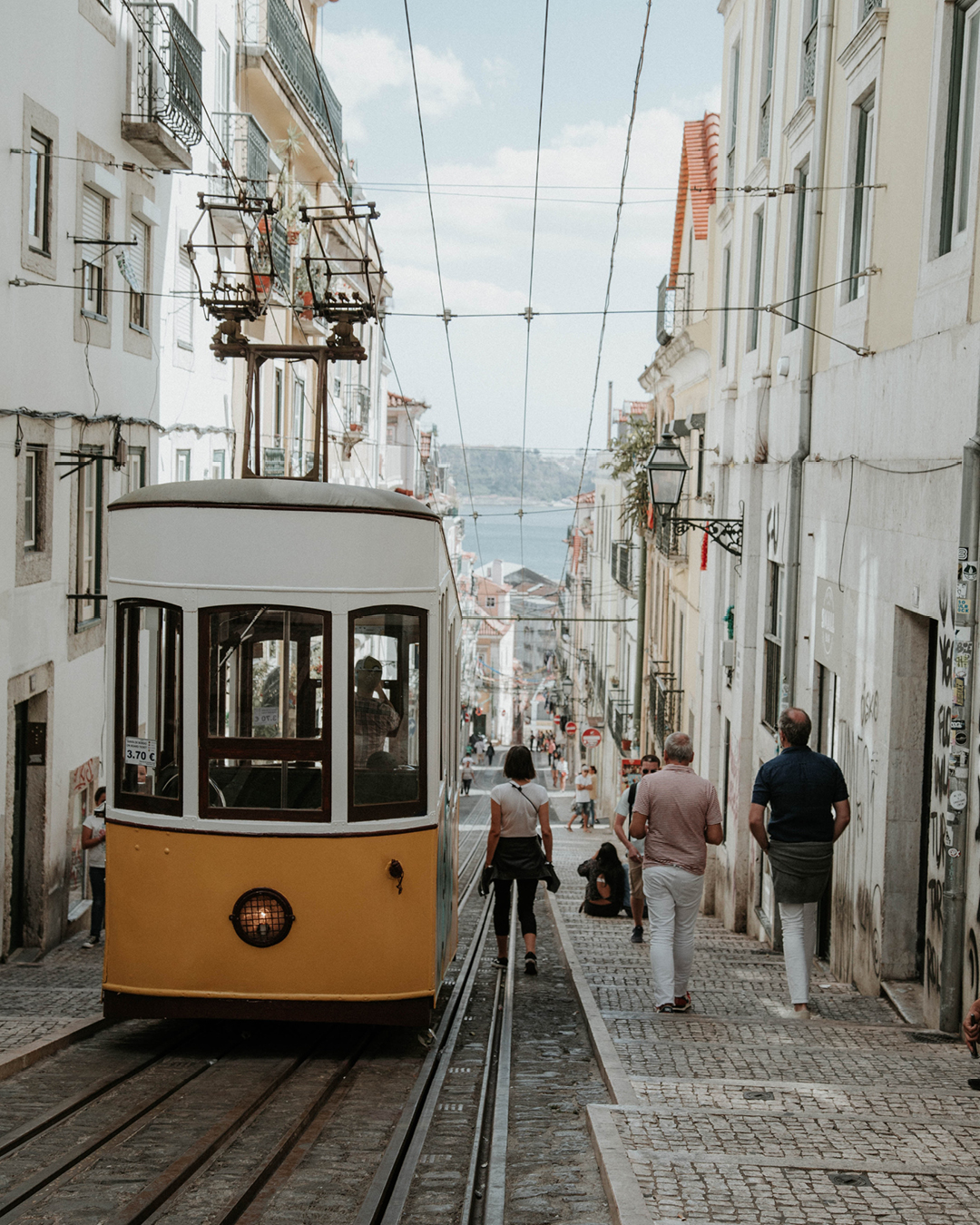 Shoreditch and Spitalfields | A yellow tram drives down a road in Lisbon