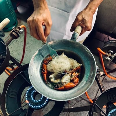 street food in bangkok | A man cooking jumbo prawns on an open air wok at Somsak Pu Ob