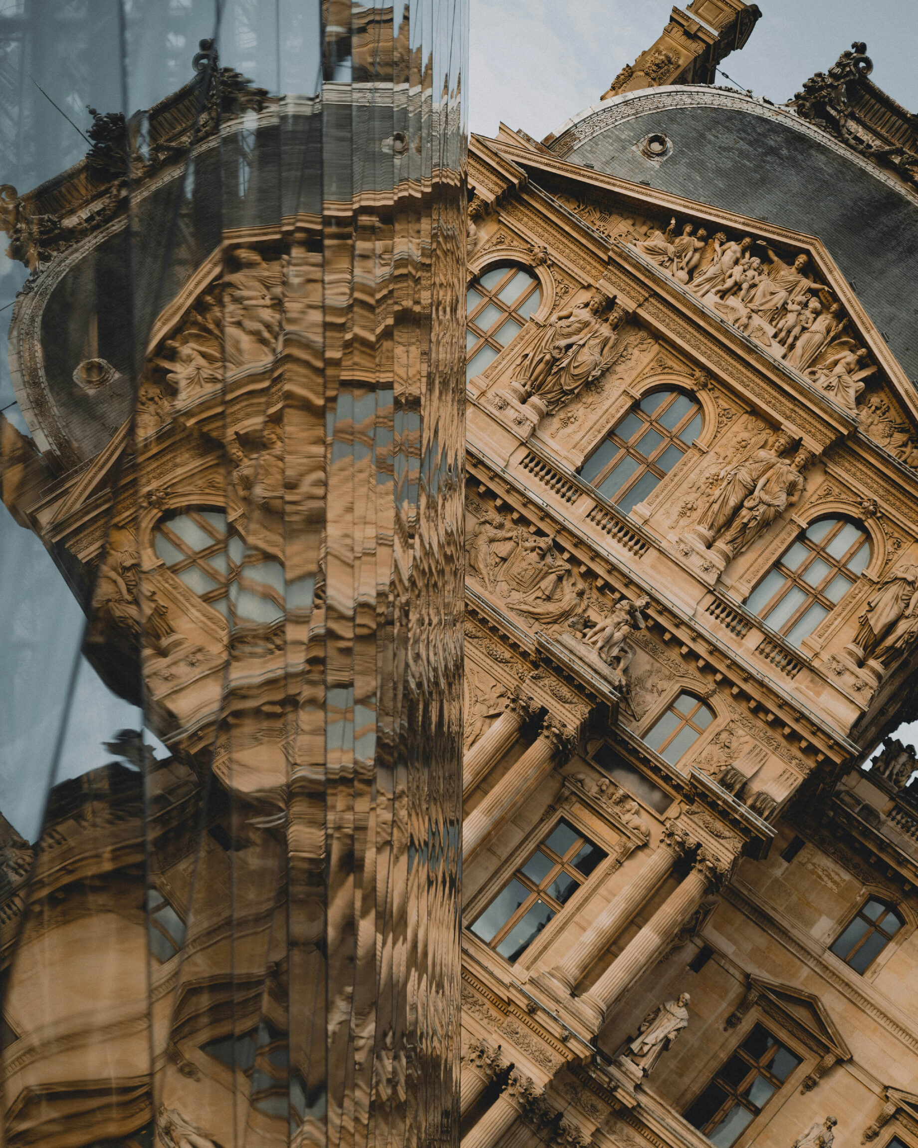 The best art galleries and museums in Paris | The historic Louvre photographed against its own reflection in glass.