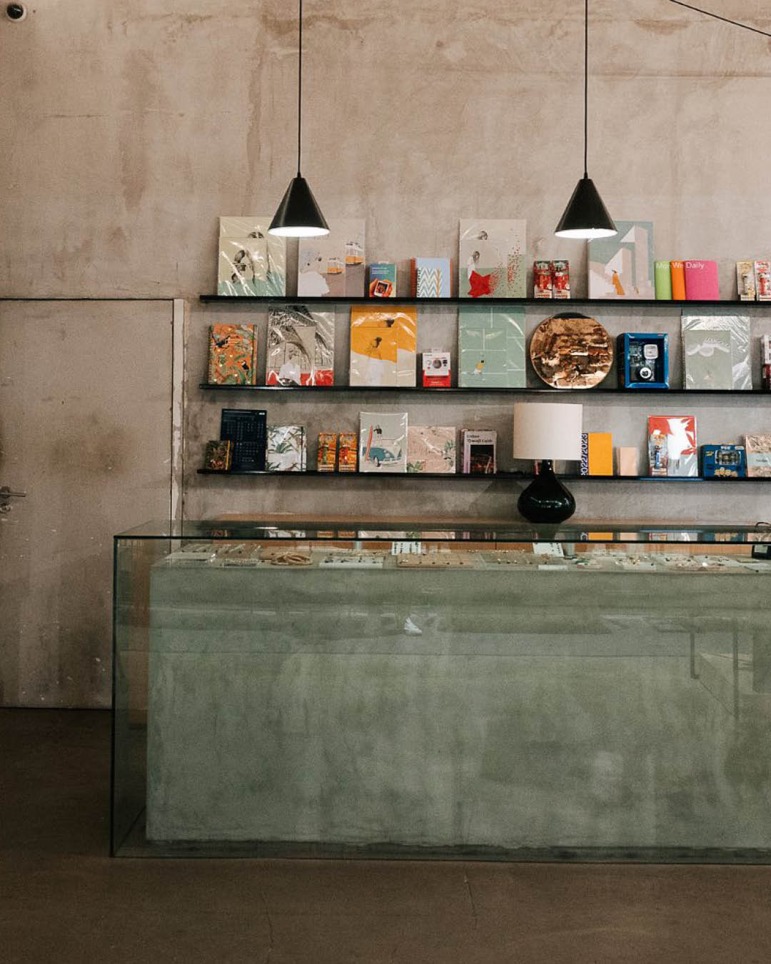 Books and magazines on display against raw plaster walls at The Feeting Room, Lisbon.