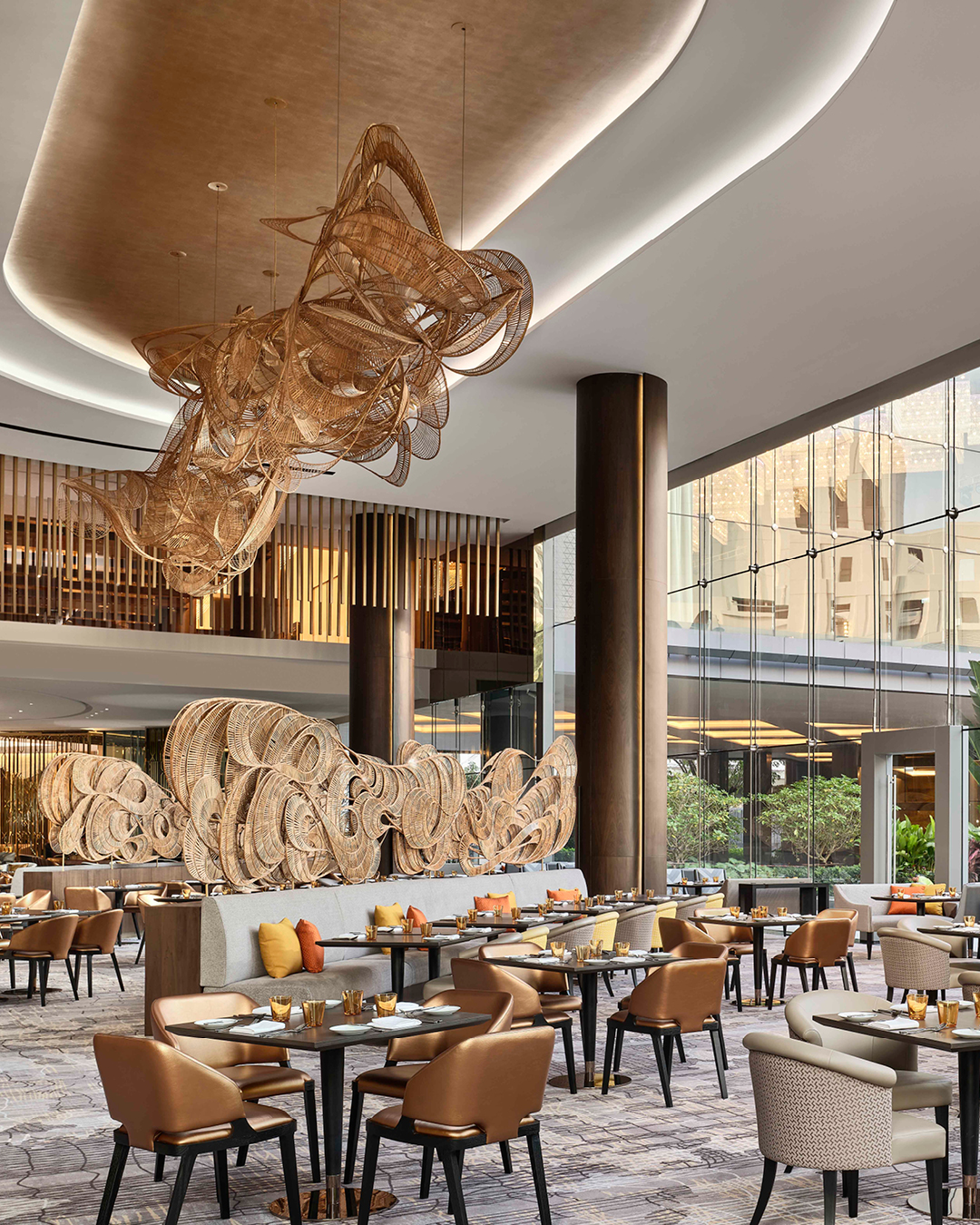 Set tables in a grand restaurant with decorative high ceiling at Chatrium Grand Bangkok