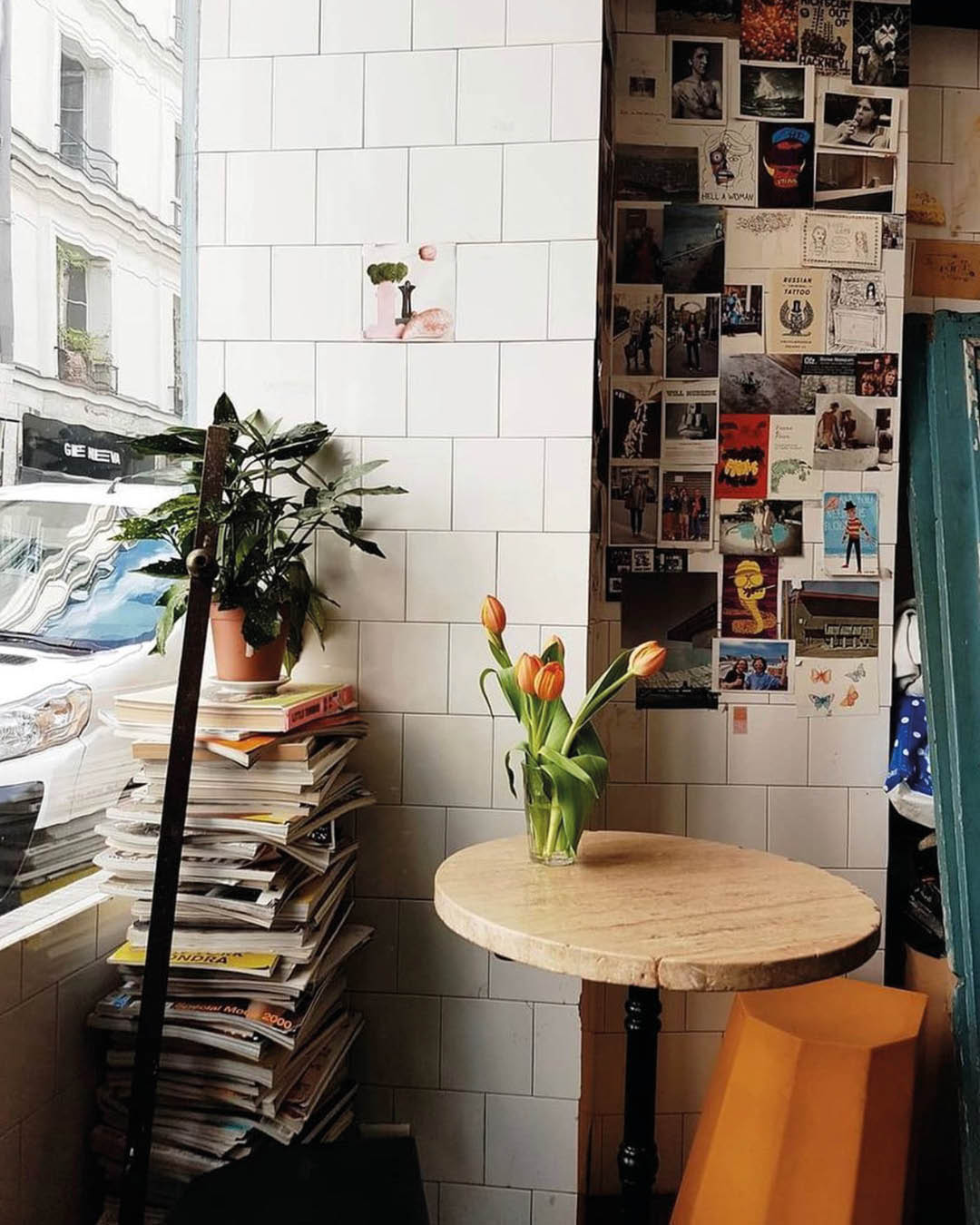 A stack of magazines next to a small table at Boot coffee shop in Paris.