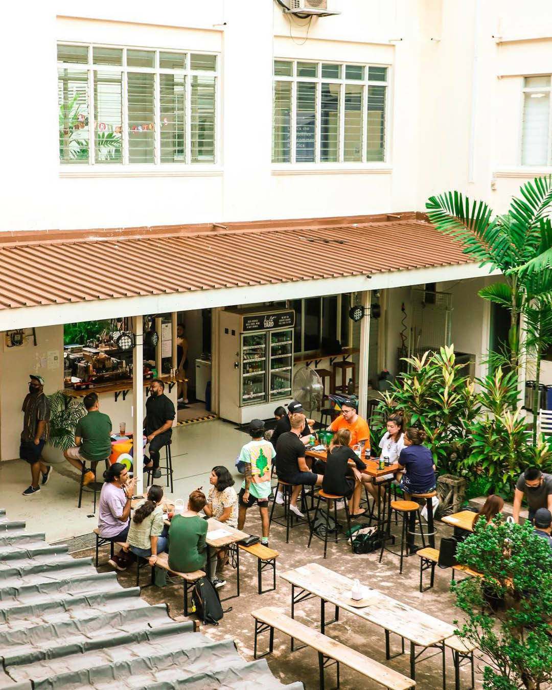 Bench and table seating in a courtyard outside at Kult Yard Singapore.