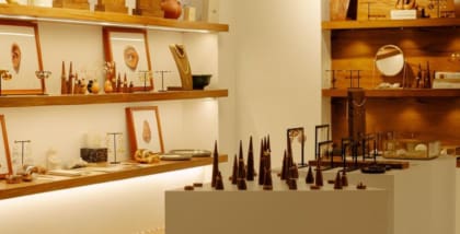 Jewellery arranged along three white shelves on a white wall in Lune boutique in Mumbai.