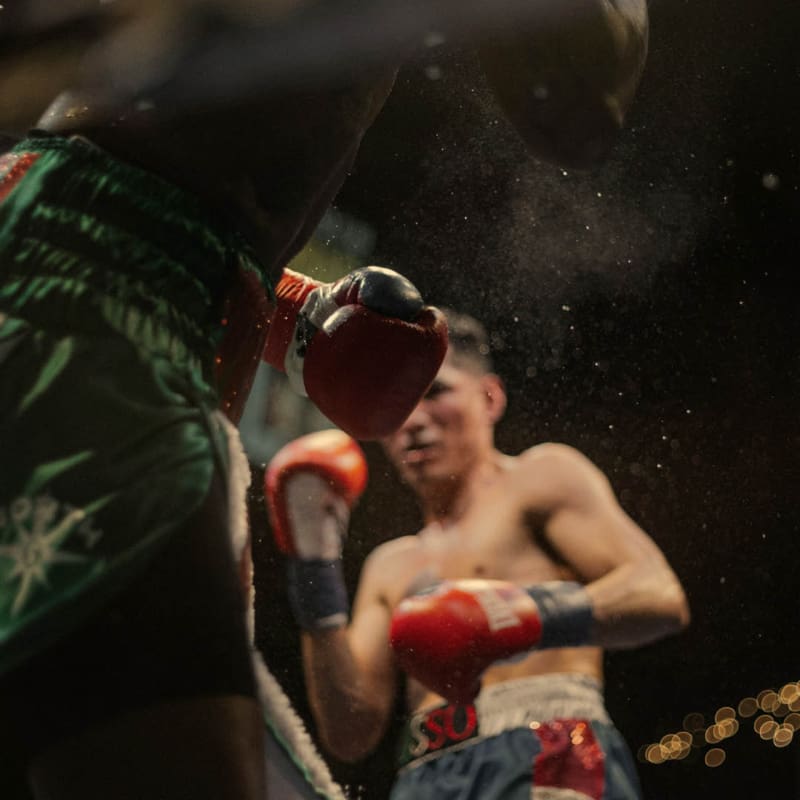 two muay thai boxers with red boxing gloves in action during a fight