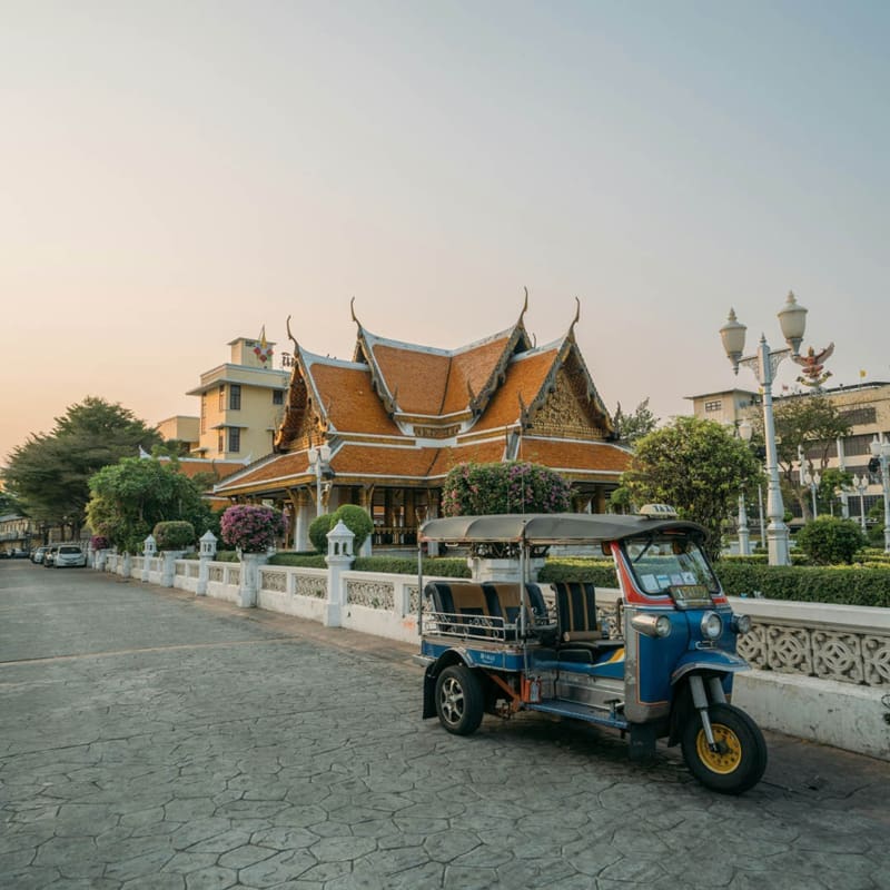 tuk tuk parked on road outside temple at sunrise