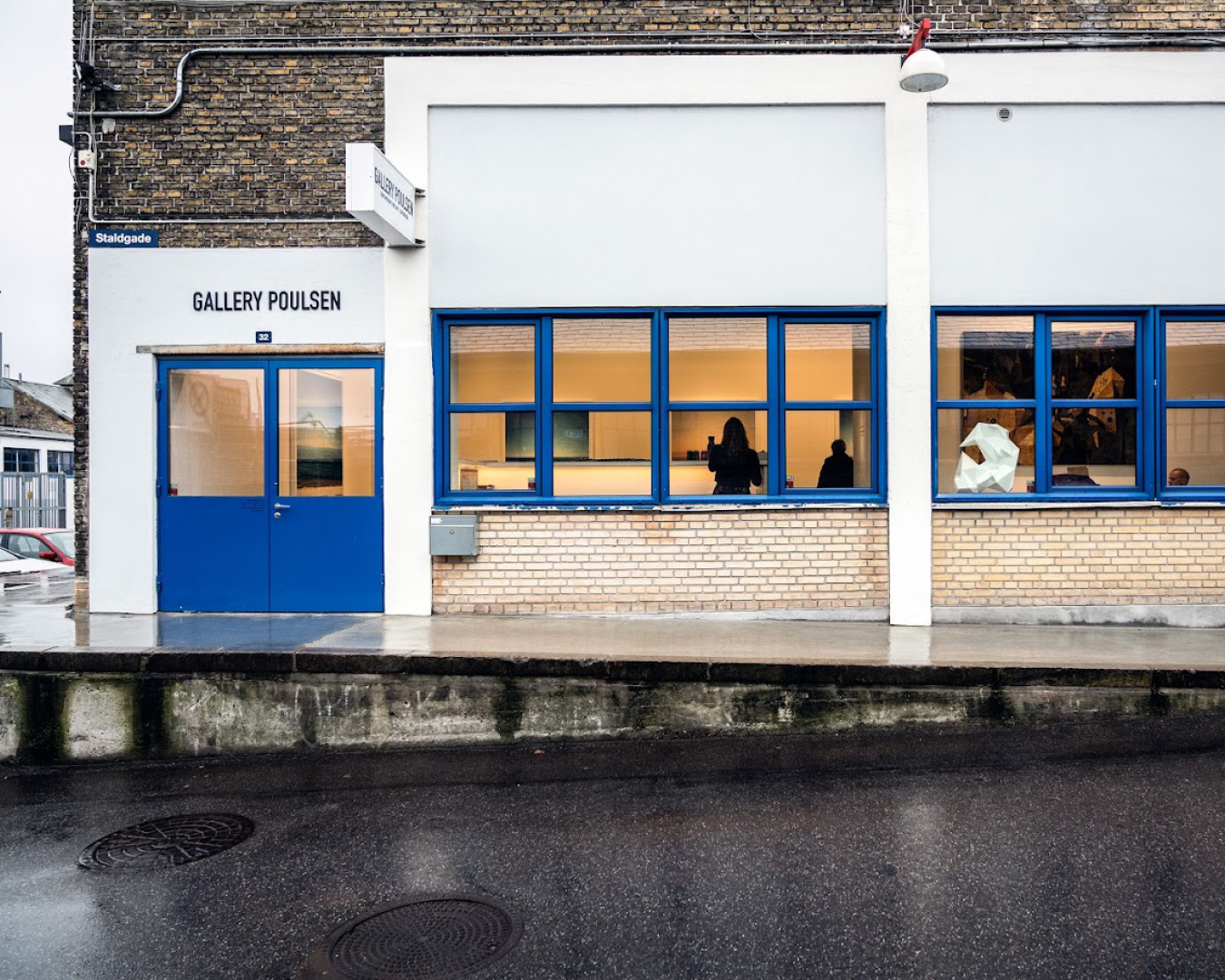 Outside Gallery Poulsen., where a blue door and window frames is set against a white building.