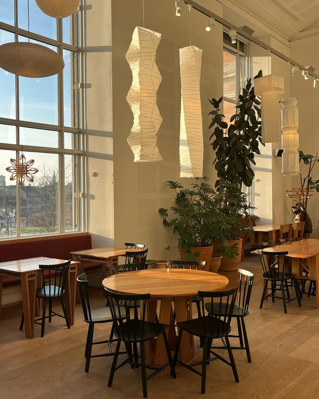 Paper lanterns, high ceilings and tables and chairs at SMK Kafeteria in Copenhagen.