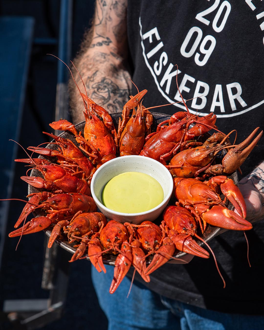 Crayfish served in a ring around a dip on a big plate outside Kødbyens Fiskebar in Copenhagen.