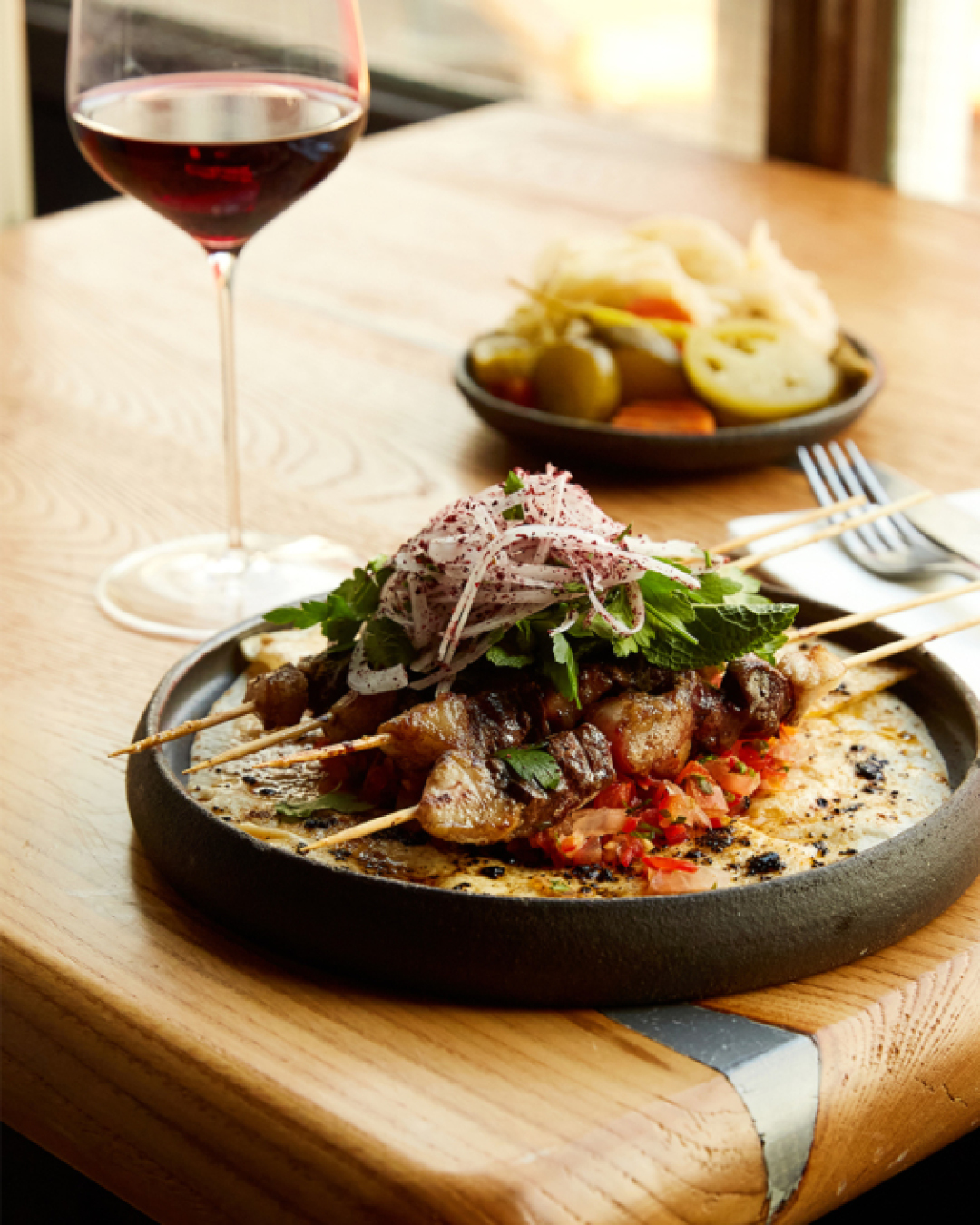 A lamb liver skewer topped with fresh chopped salad