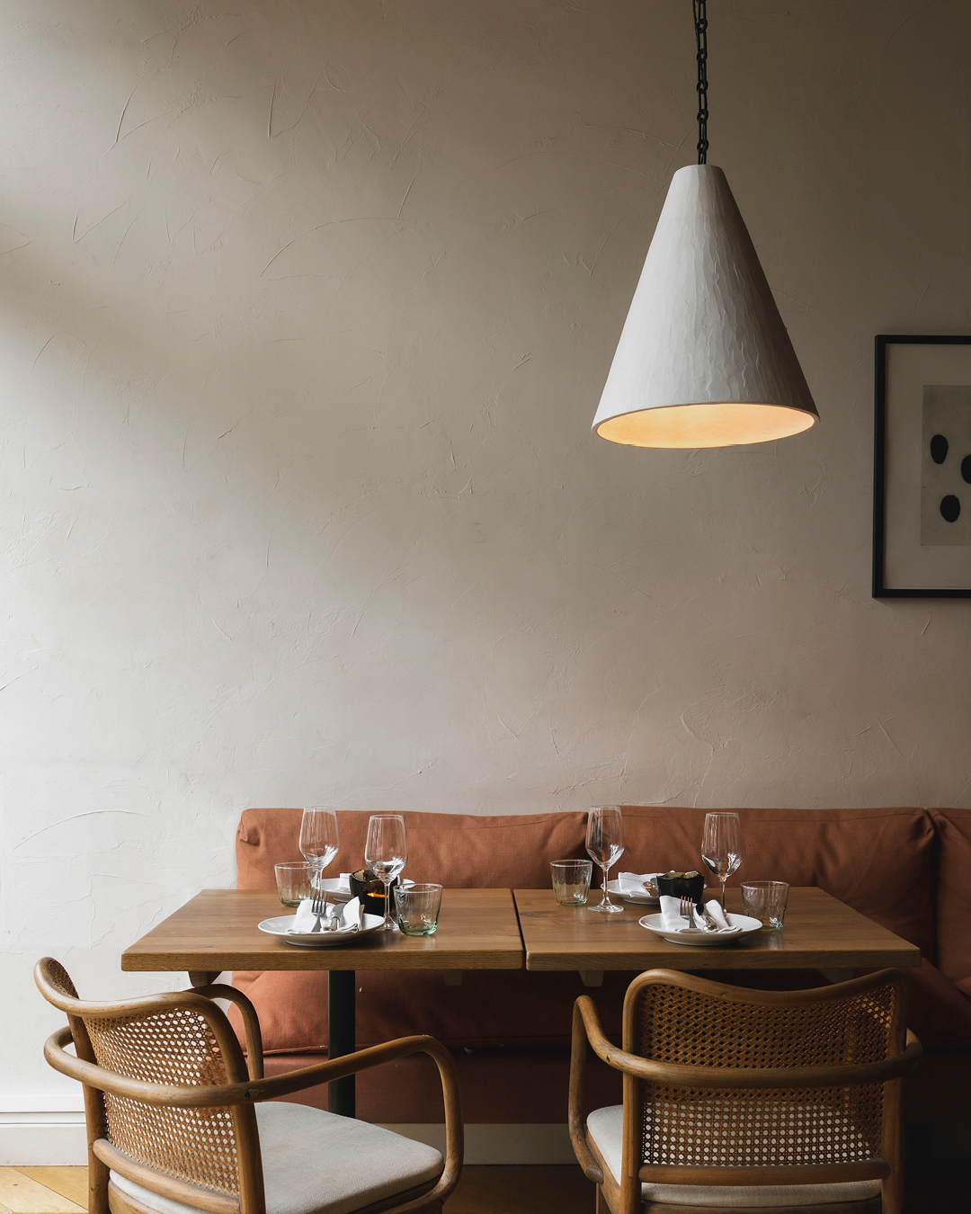 A low-lit table setting at Orasay with rattan chairs