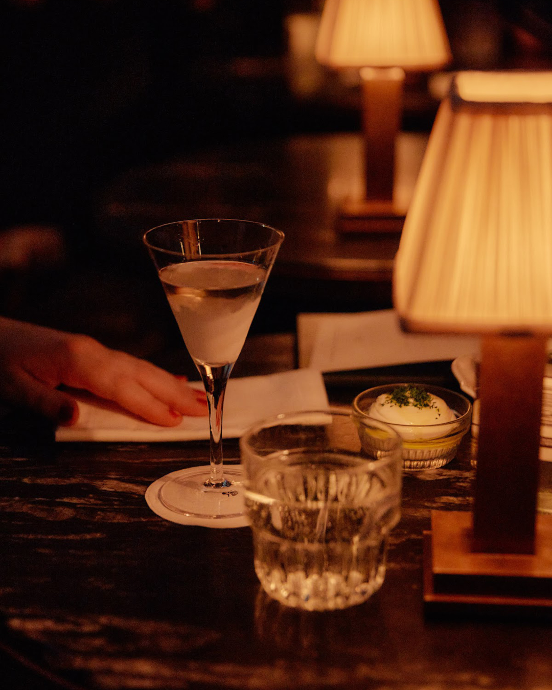 Guests enjoying cocktails at Apollo Inn under dimmed lights