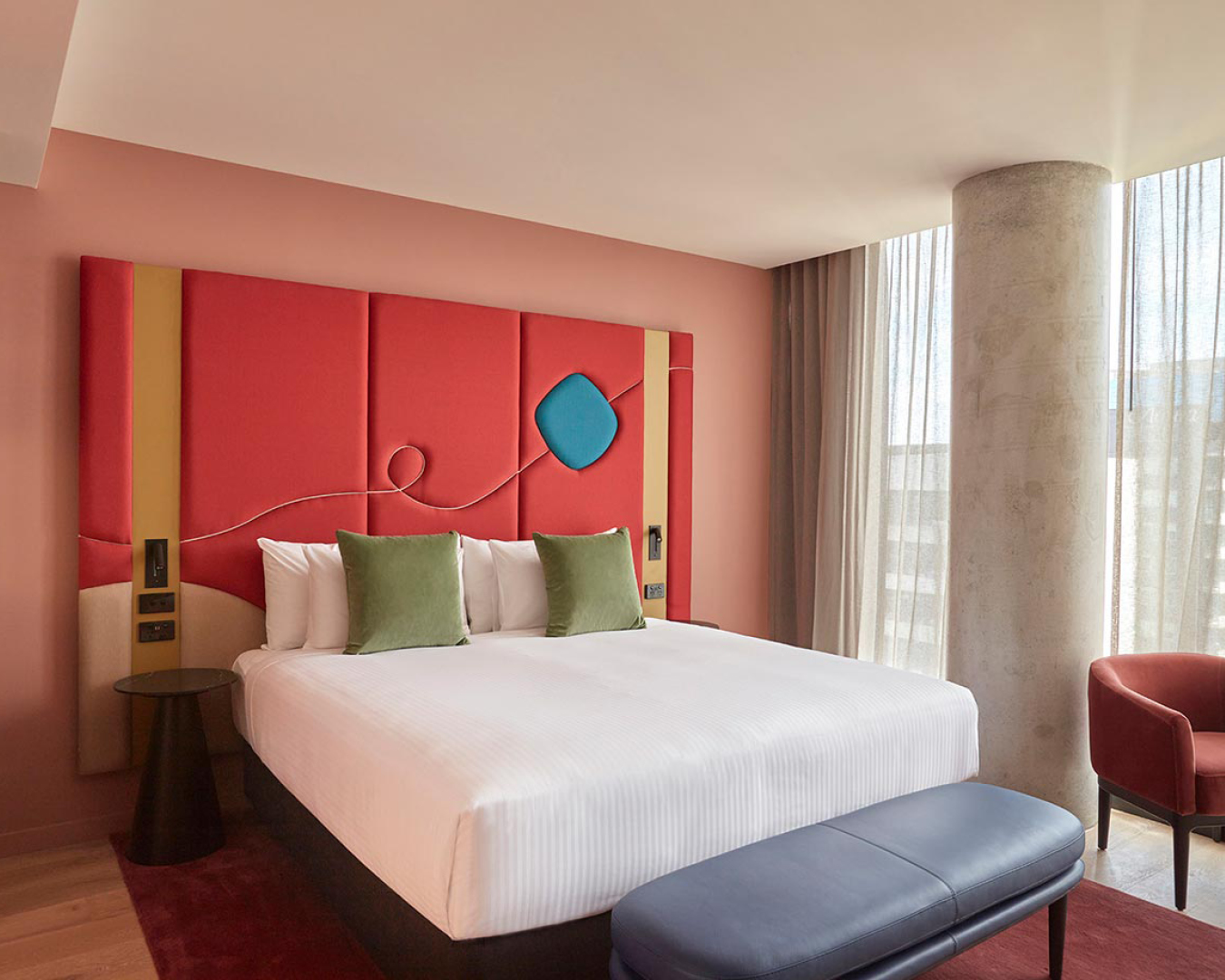 A colourful, abstract headboard inside a suite at Quincy Hotel in Melbourne