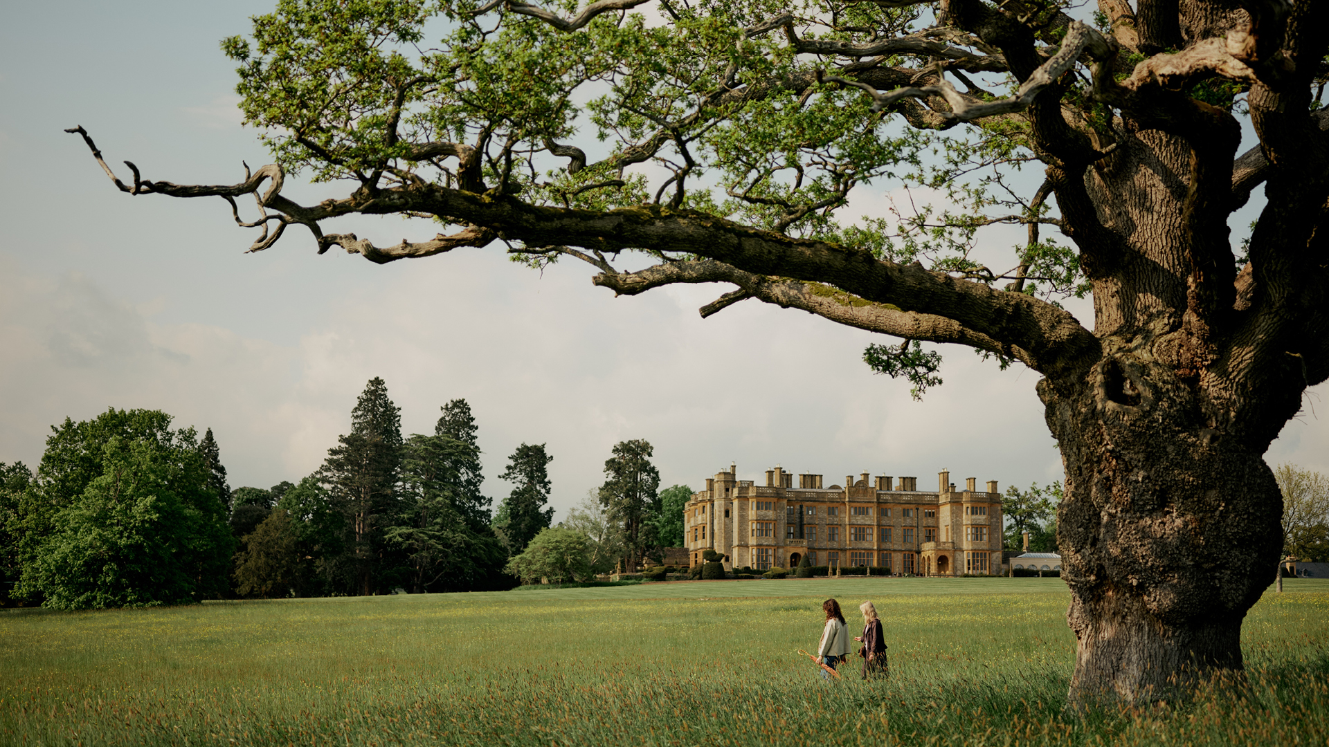 A couple stroll through stunning overgrown greenery that frames Estelle Manor