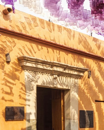 Papel picado bunting hangs above a building in Oaxaca